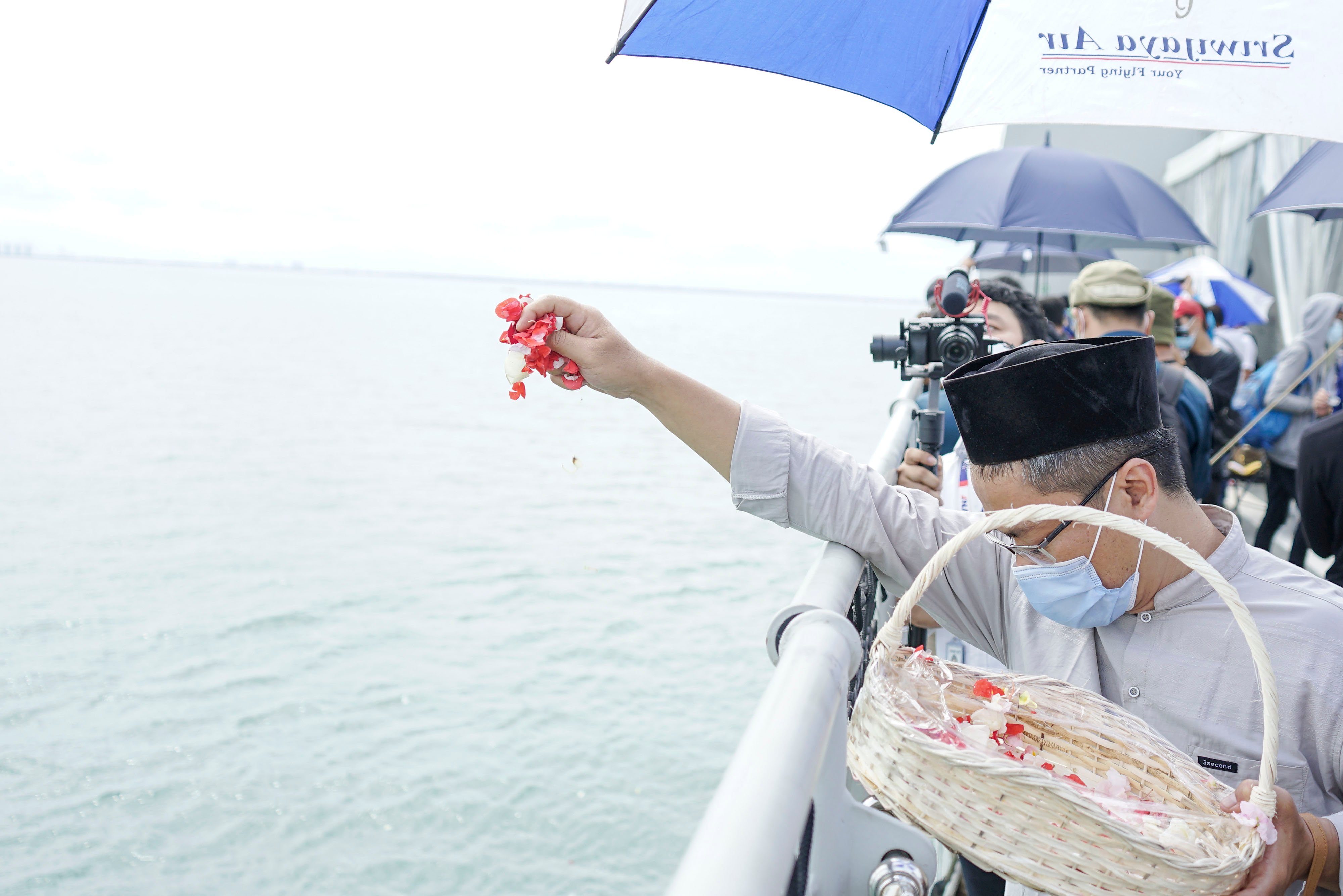 Keluarga korban pesawat SJ 182 melarungkan bunga di lokasi kecelakaan pesawat