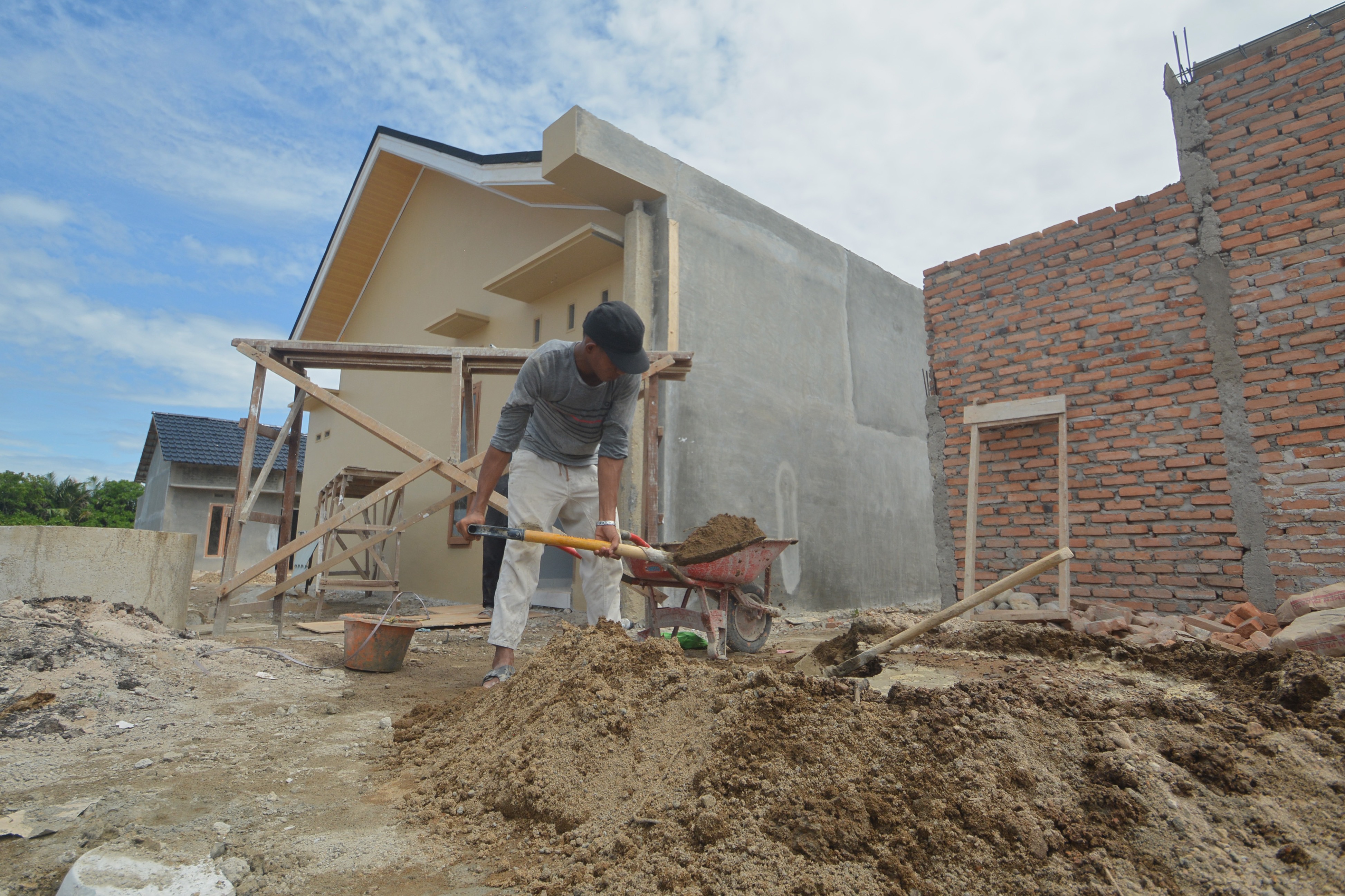 Pekerja melanjutkan pembangunan rumah di kawasan perumahan KPR subsidi di Lubuk Buaya, Padang, Sumatra Barat, Kamis (18/2).
