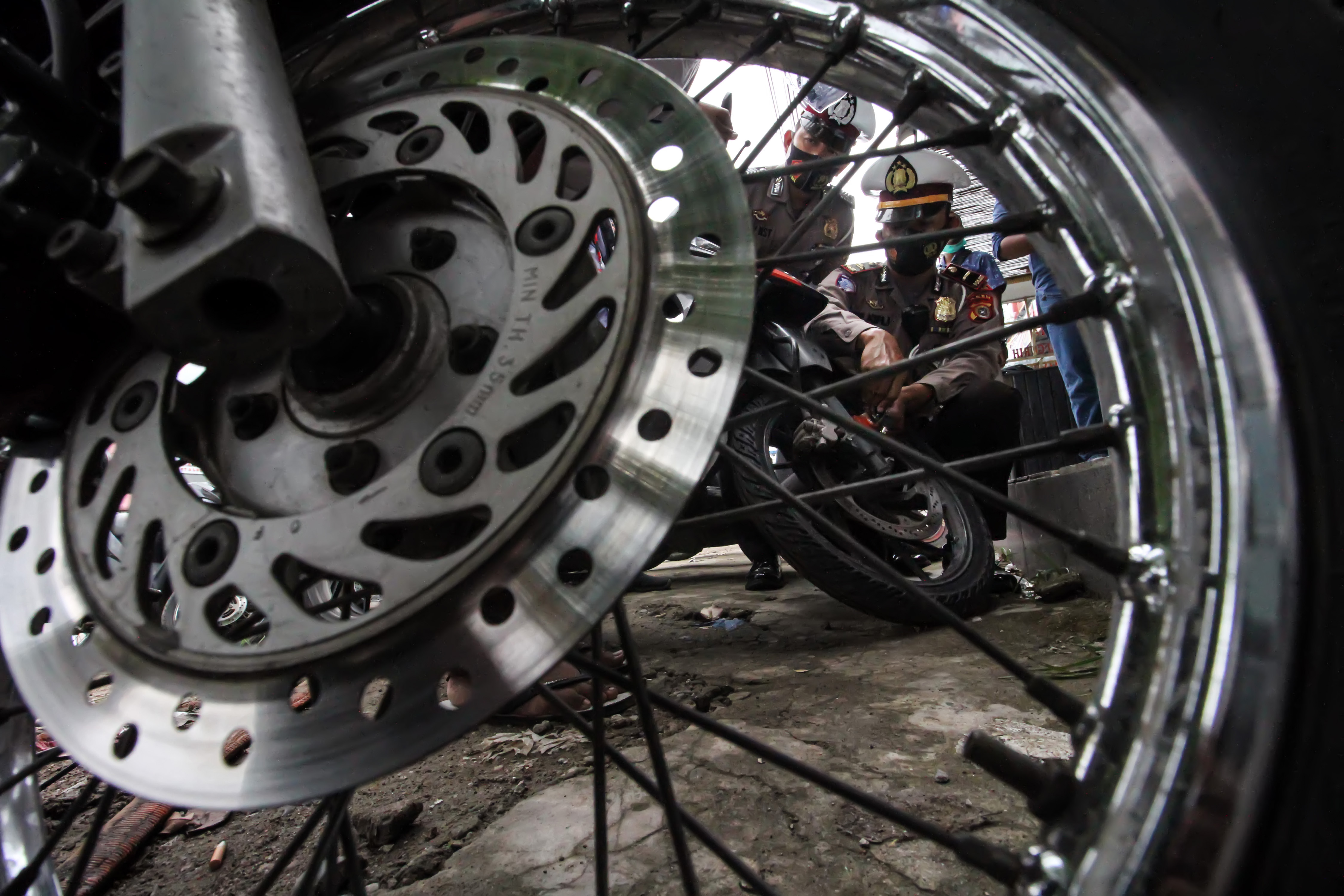 Ilustrasi polisi memasang kunci ganda gratis untuk mencegah pencurian motor.