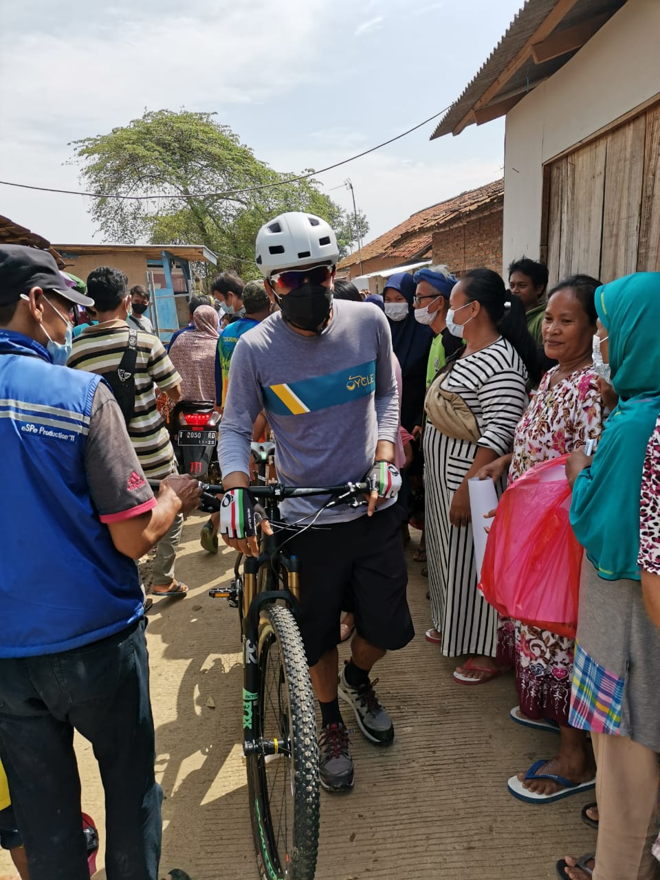 Ketua NasDem Jawa Barat Saan Mustopa sambil bersepeda membagikan bantuan sembako bagi korban banjir di Karawang