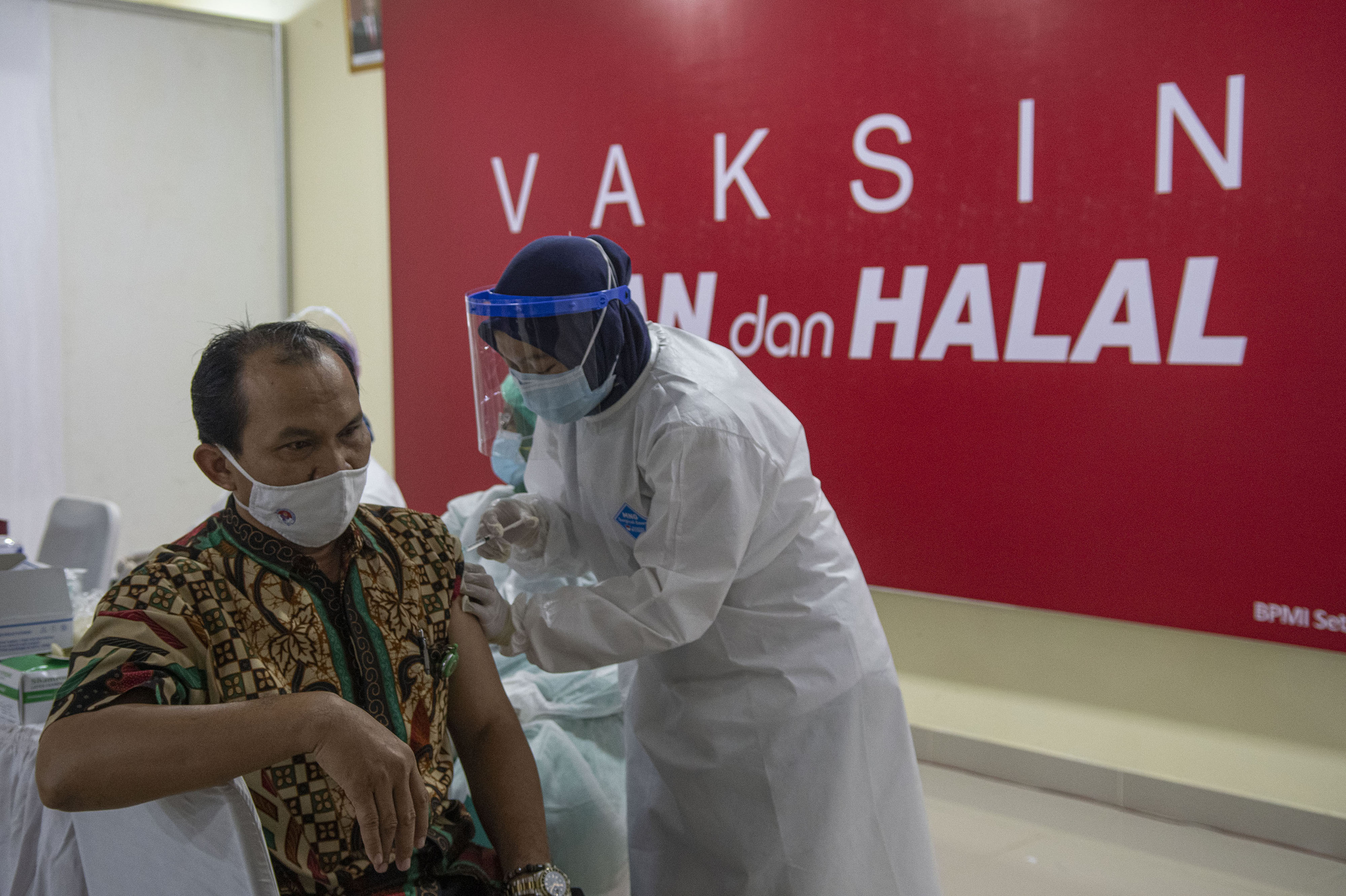  Petugas menyuntikkan vaksin covid-19 pada tenaga pengajar dalam acara vaksinasi massal di SMA Negeri 70 Jakarta, Jakarta, Rabu (24/2/2021).