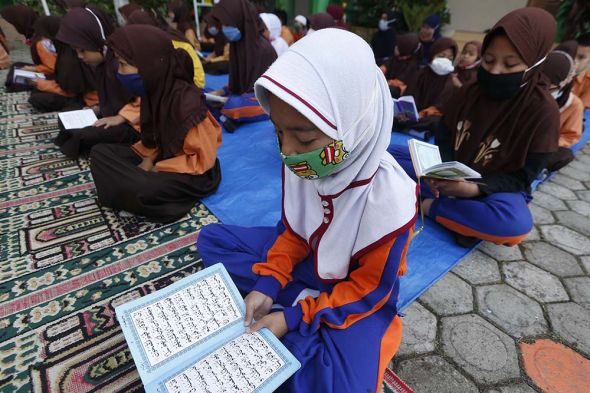 Pelajar SD memakai seragam pramuka dan pakaian olahraga dilengkapi kerudung (jilbab) saat mengikuti aktivitas belajar mengajar di Aceh.
