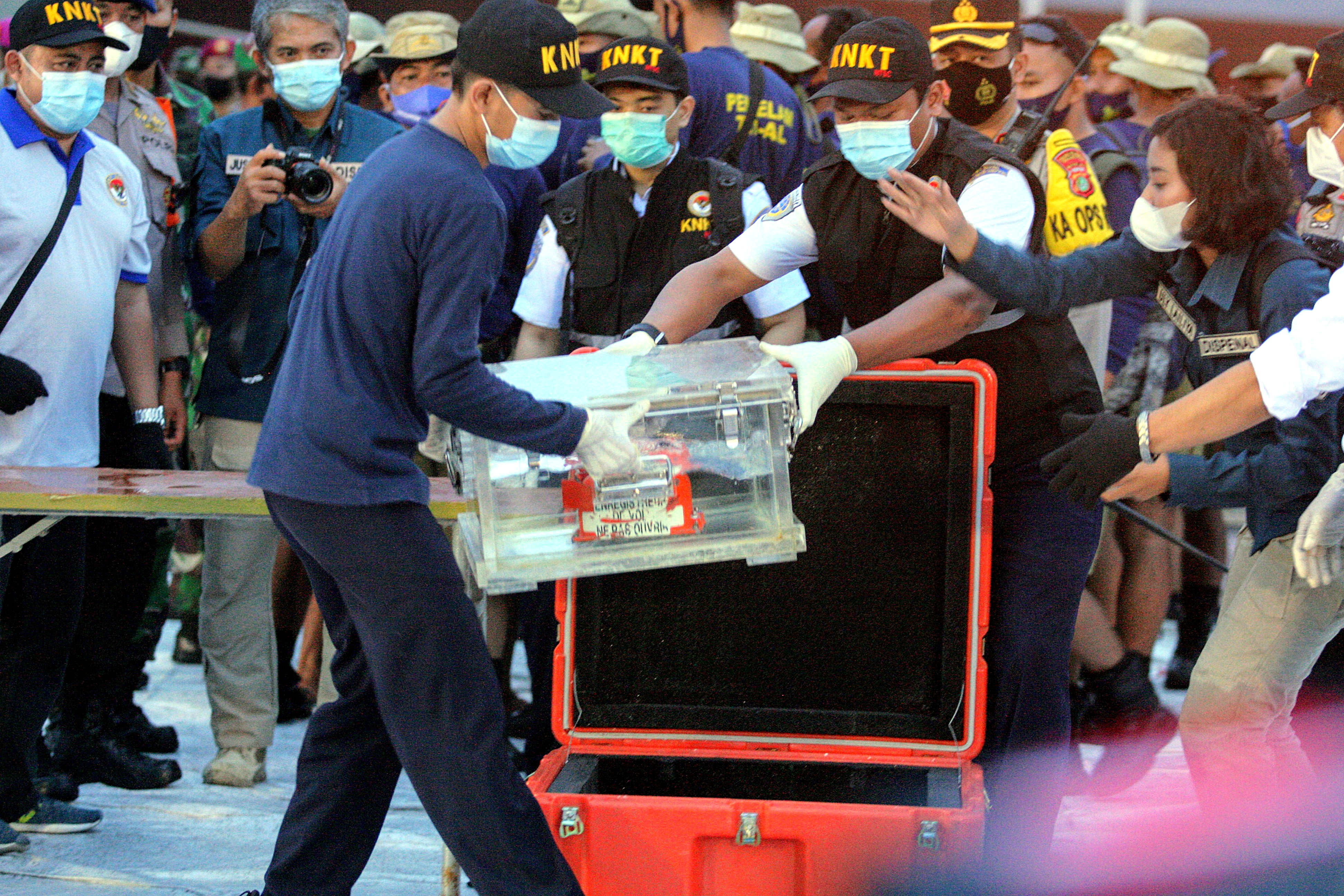 Petugas KNKT mengangkat perangkat flight data recorder (FDR) yang merupakan bagian dari black box pesawat Sriwijaya Air SJ-182.