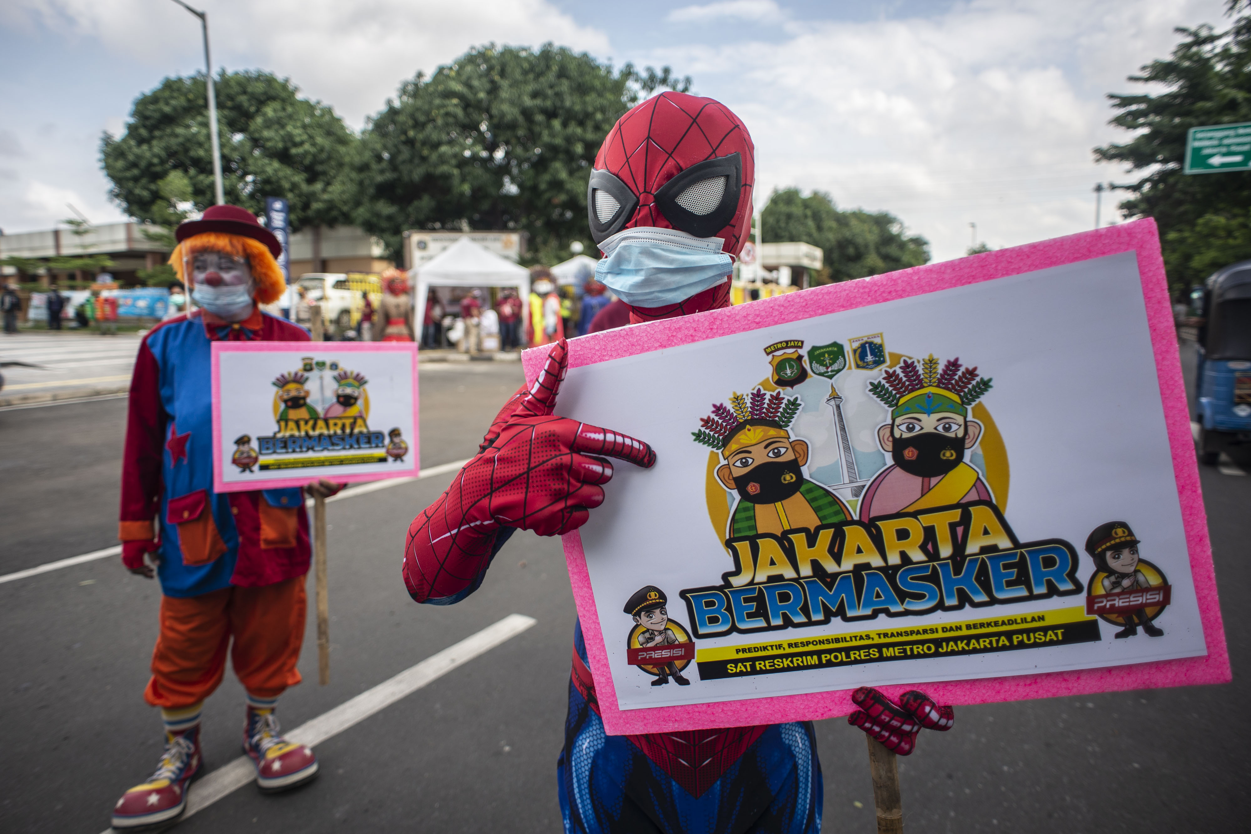  Pekerja seni berkostum badut dan tokoh superhero mensosialisasikan penggunaan masker di Jakarta, Kamis (4/2).
