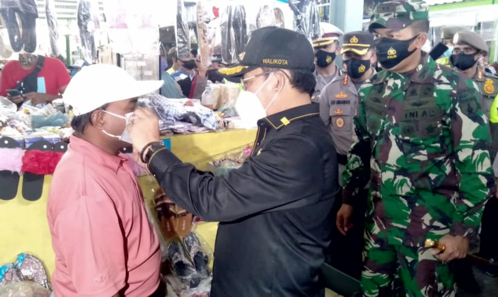 Wali Kota Malang Sutiaji, membetulkan pemakain masker ke pedagang saat sidak di pasar tradisional.