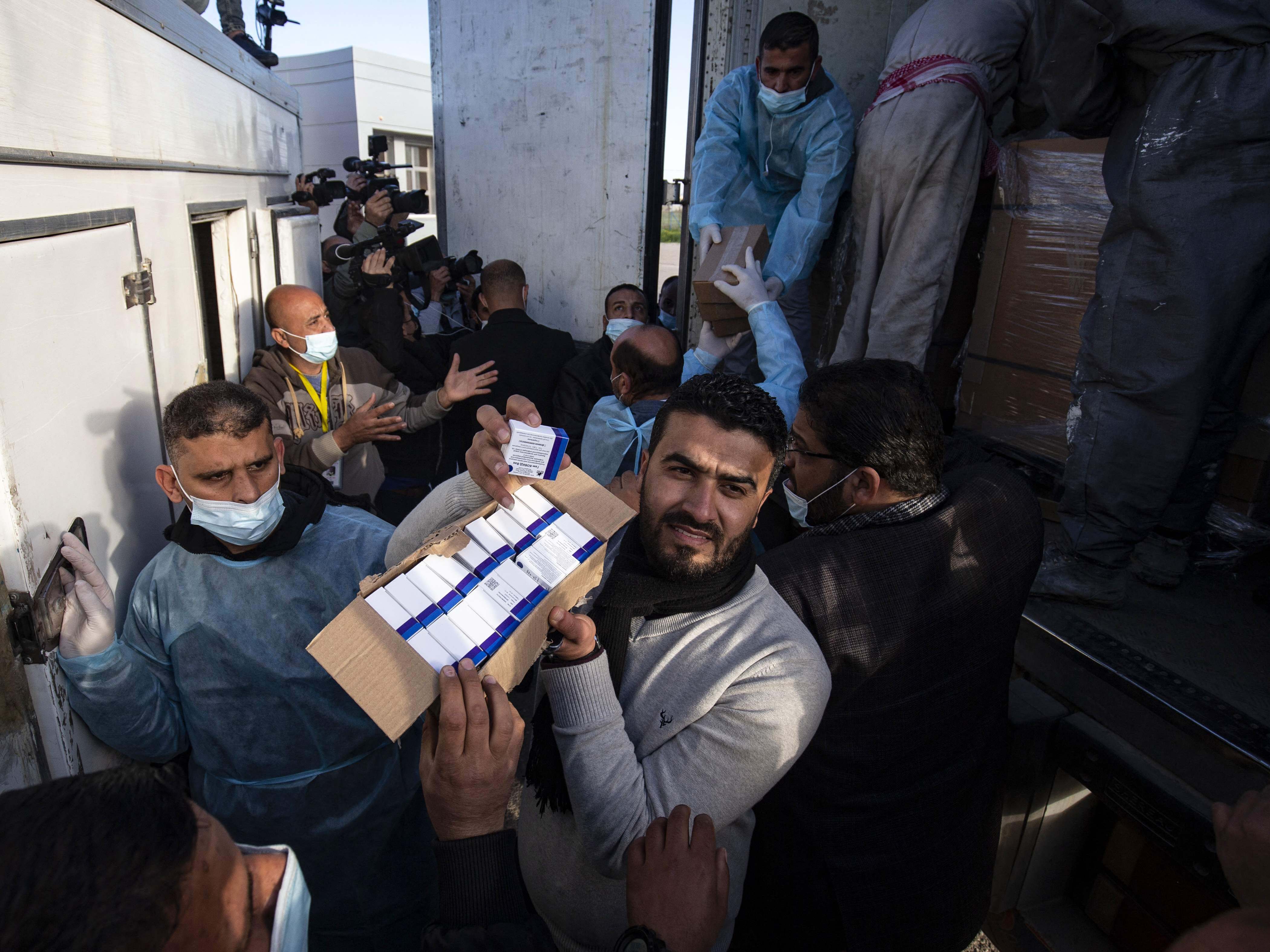 Para pekerja menurunkan sejumlah boks vaksin Sputnik V buatan Rusia dari UEA dari truk, Minggu (21/2).