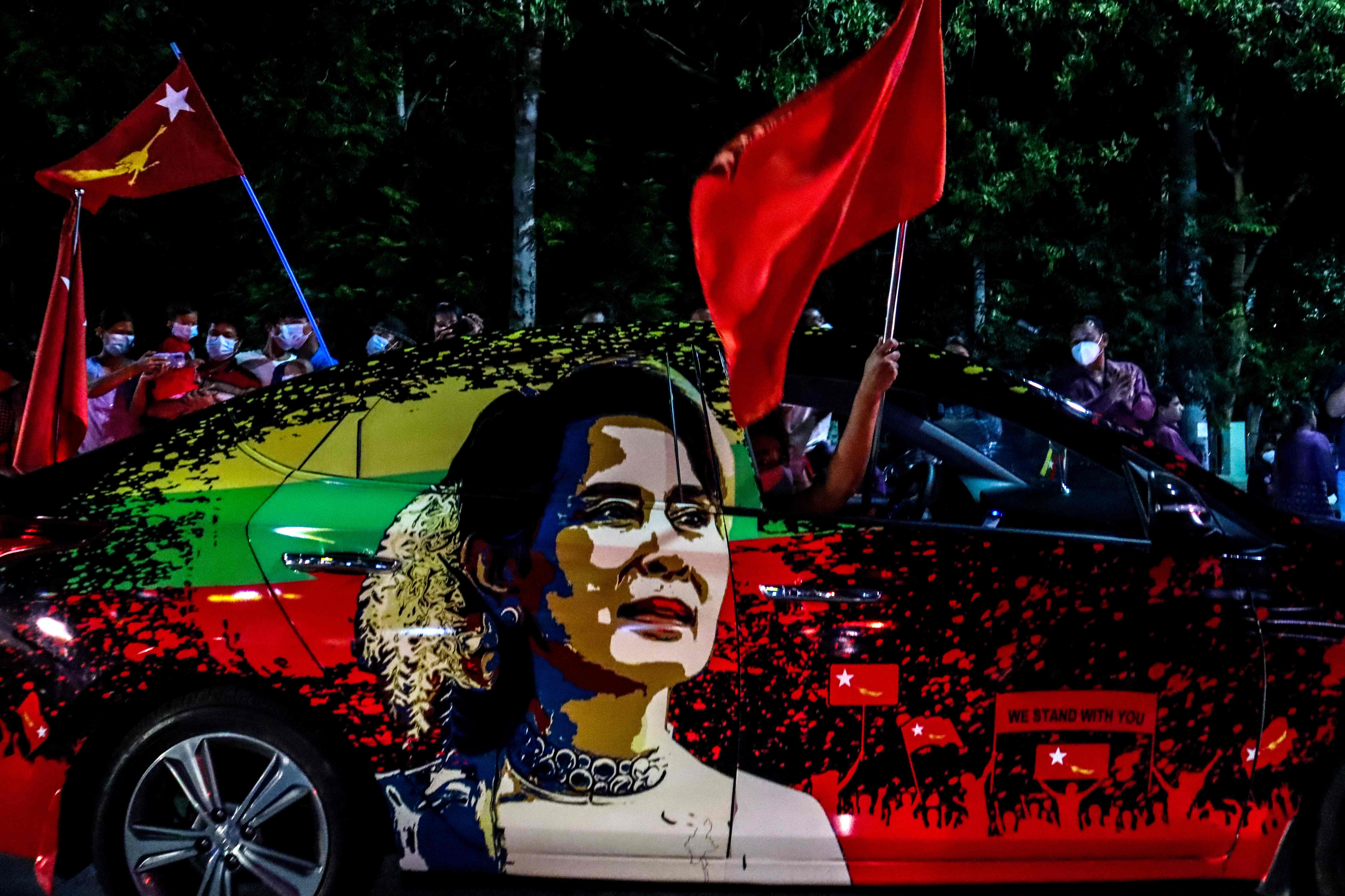 Para pendukung Partai Liga Nasional (NLD) untuk Demokrasi dengan menaiki kendaraan bergambar Aung San Suu Kyi berparade.