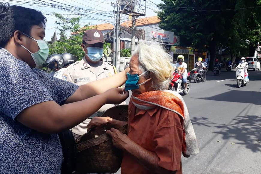 Krama (warga) dan prajuru (pengurus) Banjar Tengah, Kelurahan Sesetan, Denpasar bagikan masker dan nasi bungkus gratis kepada warga.