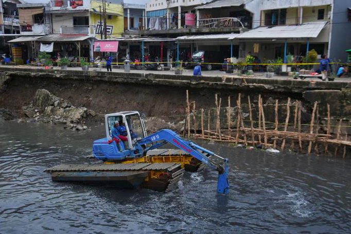 Petugas UPK Badan Air tengah memperbaiki turap Kali Sunter yang ambles di Jalan Cinta, Pulogadung, Jakarta Timur, Rabu (8/1) 