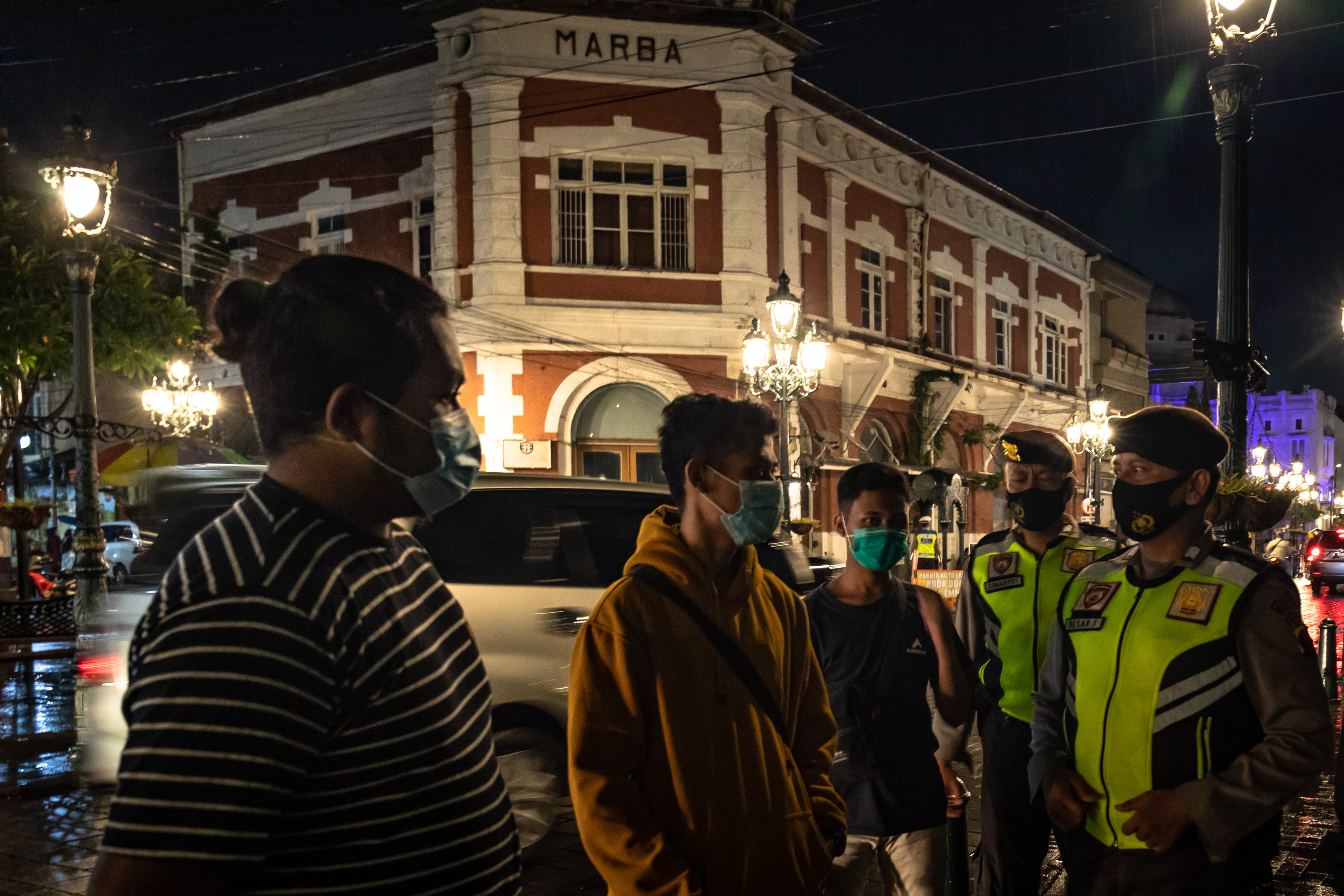 Petugas kepolisian memberi imbauan protokol kesehatan kepada wisatawan saat Operasi Yustisi COVID-19 di Kawasan Kota Lama Semarang