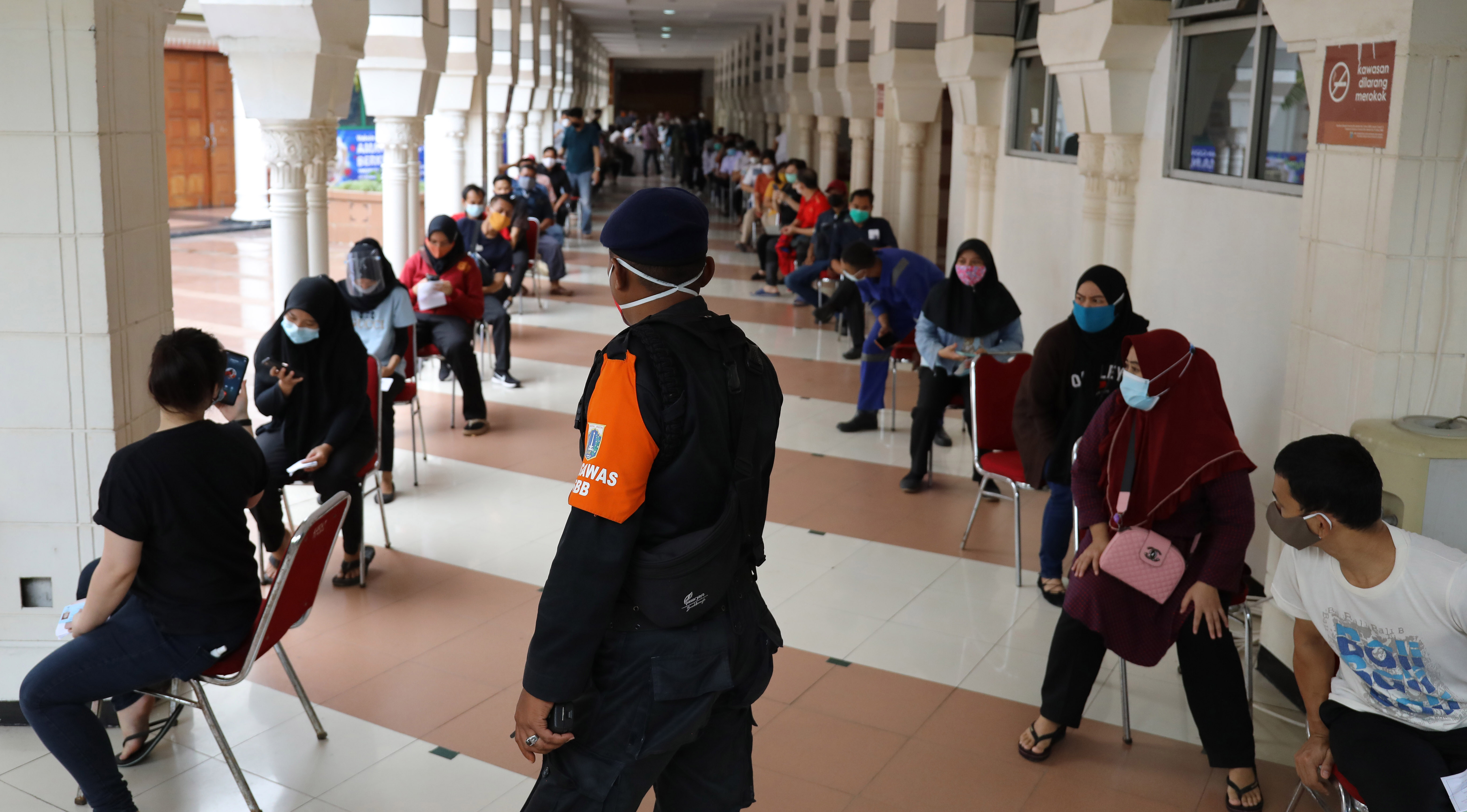 Pedagang dan pemilik toko antre mengikuti vaksinasi Covid-19 di Pasar Tanah Abang, Jakarta, Rabu (17/2).