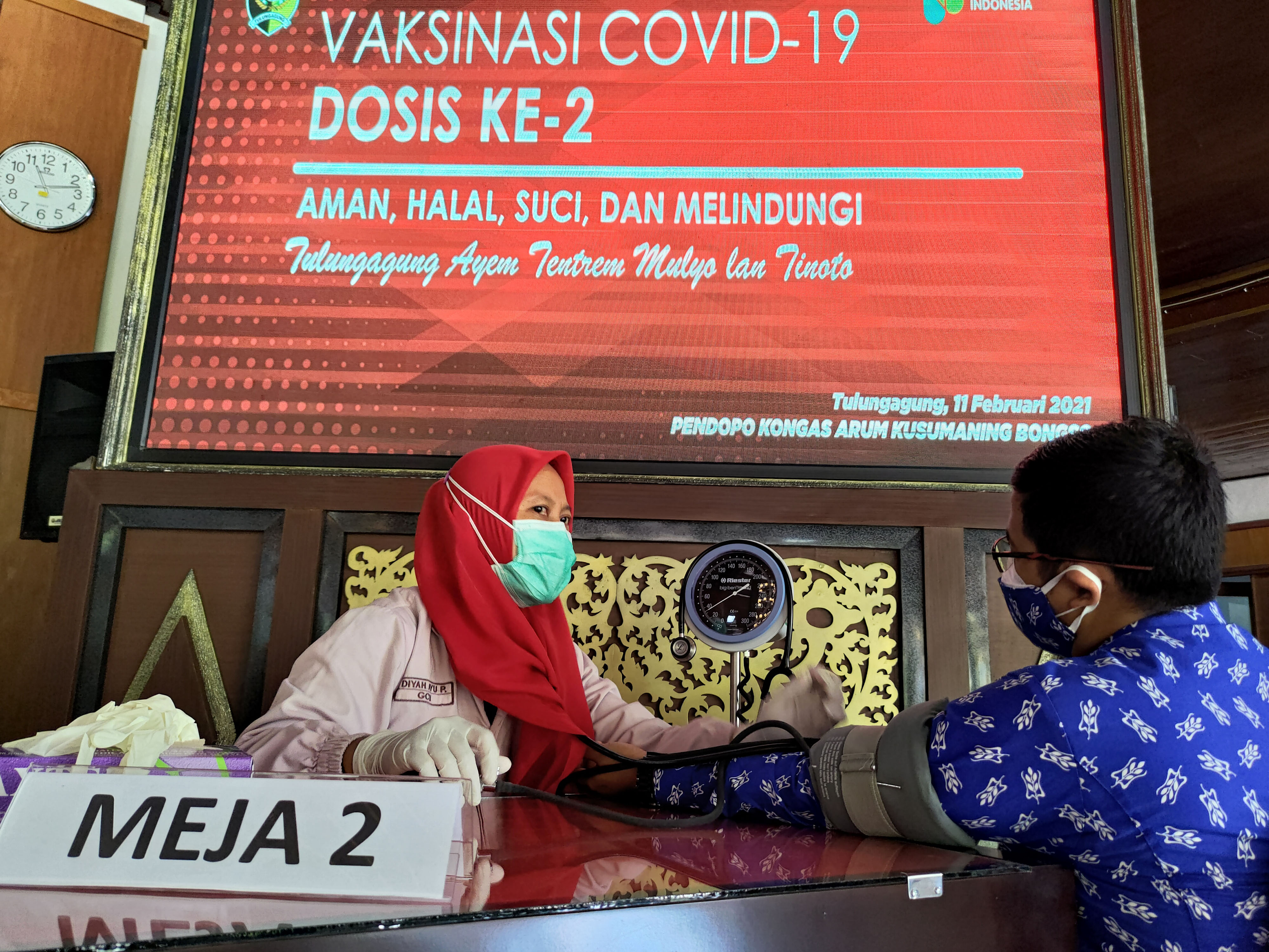 Petugas memeriksa kesehatan calon penerima vaksin saat pelaksanaan vaksinasi gelombang 2 di Tulungagung, Jawa Timur, Kamis (11/2).