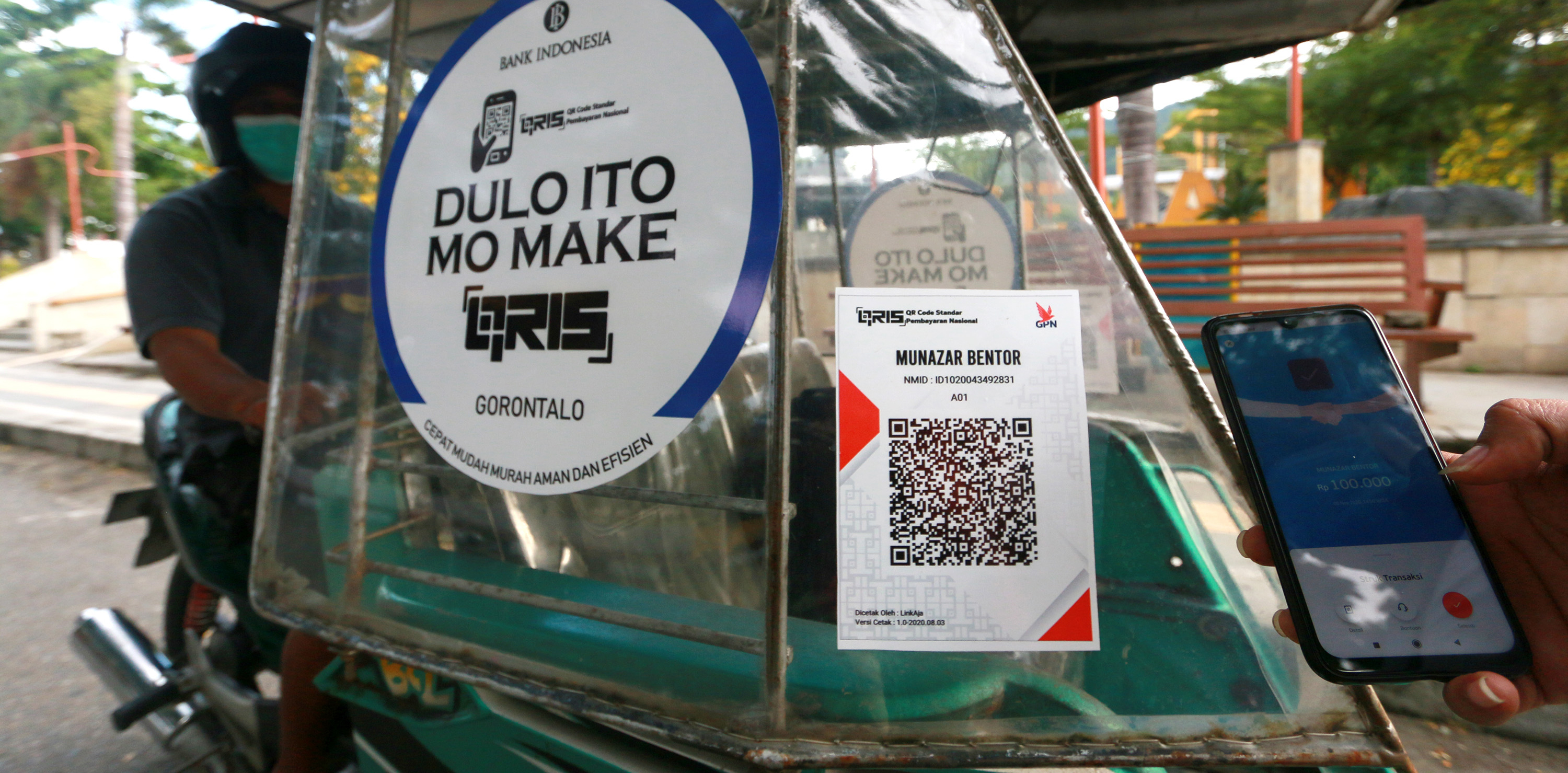 Penumpang membayar ongkos becak motor (bentor) dengan menggunakan pembayaran digital di Lapangan Taruna Remaja, Kota Gorontalo, Gorontalo.