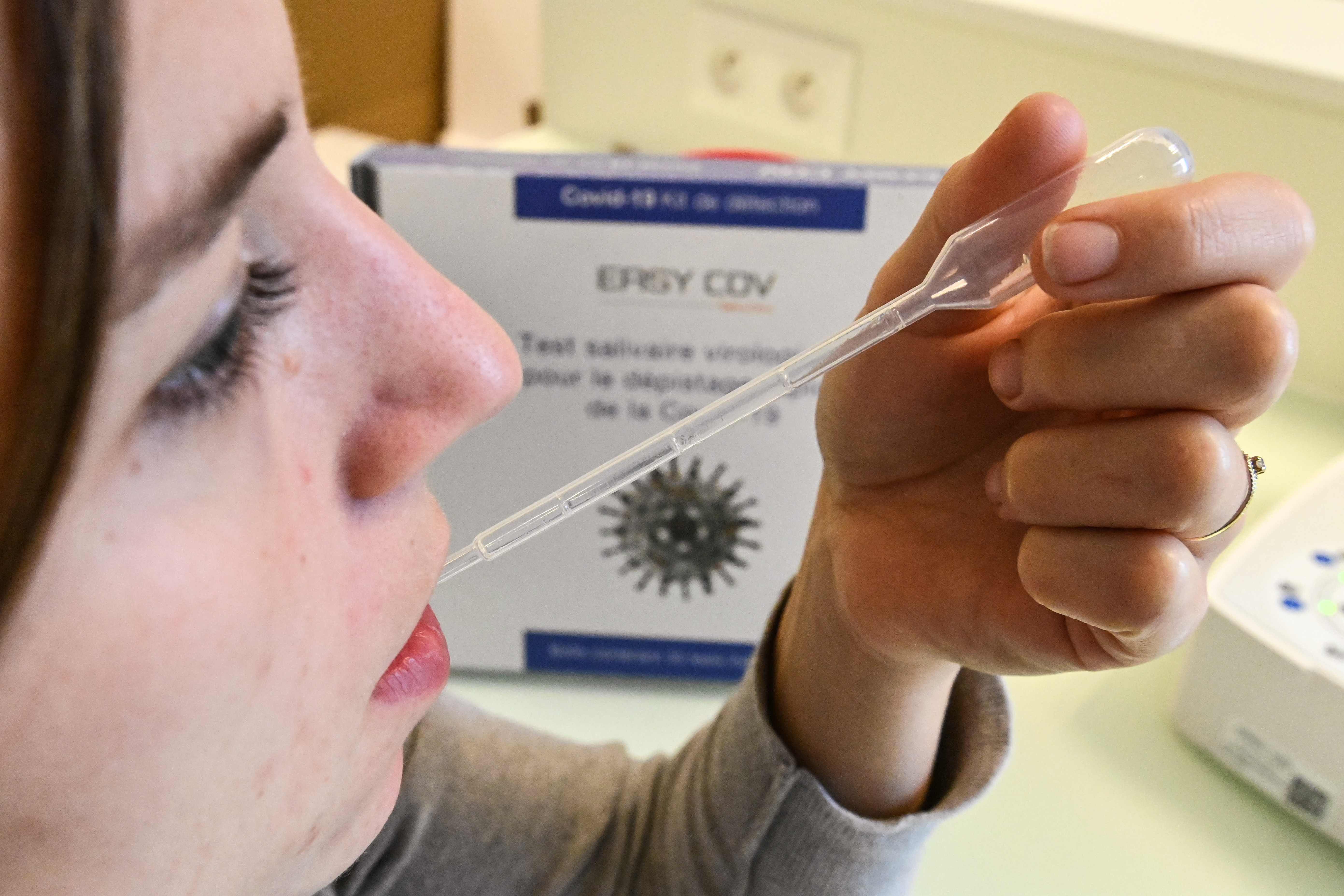 Seorang wanita mengambil sampel air liur untuk melakukan skrining cepat untuk covid-19, di Montpellier, Prancis selatan.