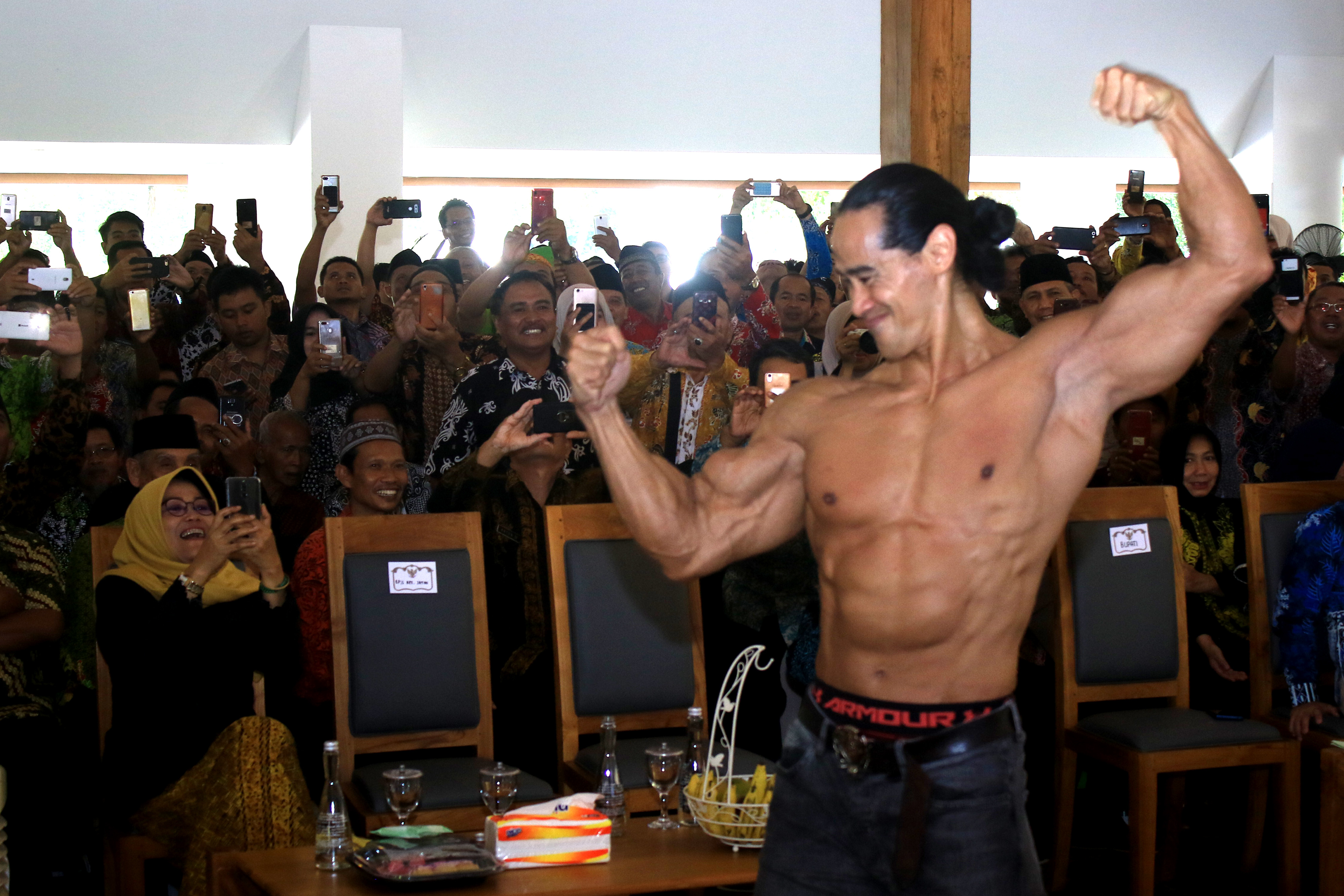 Duta BPJS Kesehatan Ade Rai menunjukan otot tubuhnya saat memberikan sosialisasi hidup sehat kepada Forum Pimpinan Daerah dan Tokoh Agama.