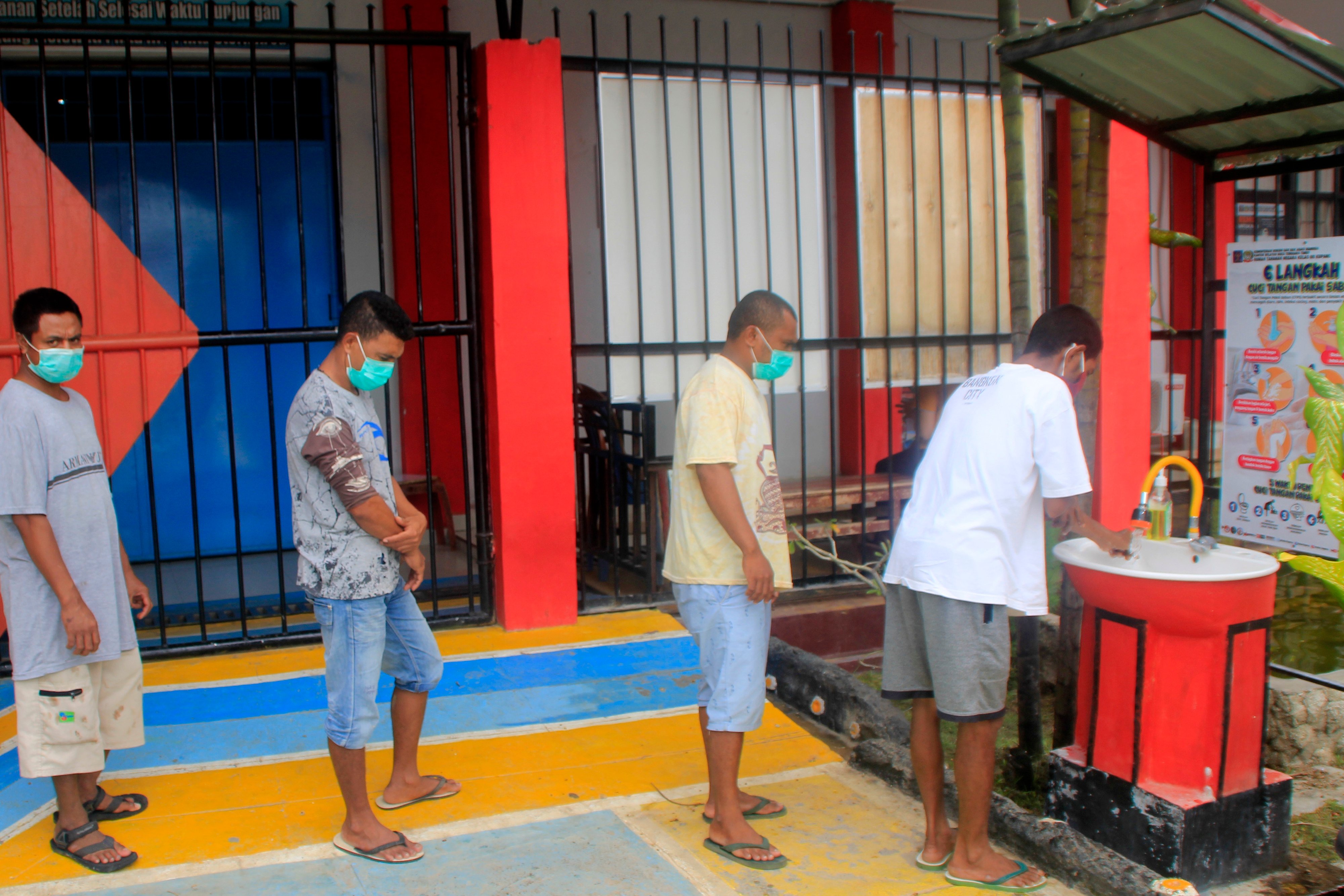 Sejumlah warga binaan di Rutan Klas IIB Kupang antre dan menjaga jarak saat mencuci tangan. 