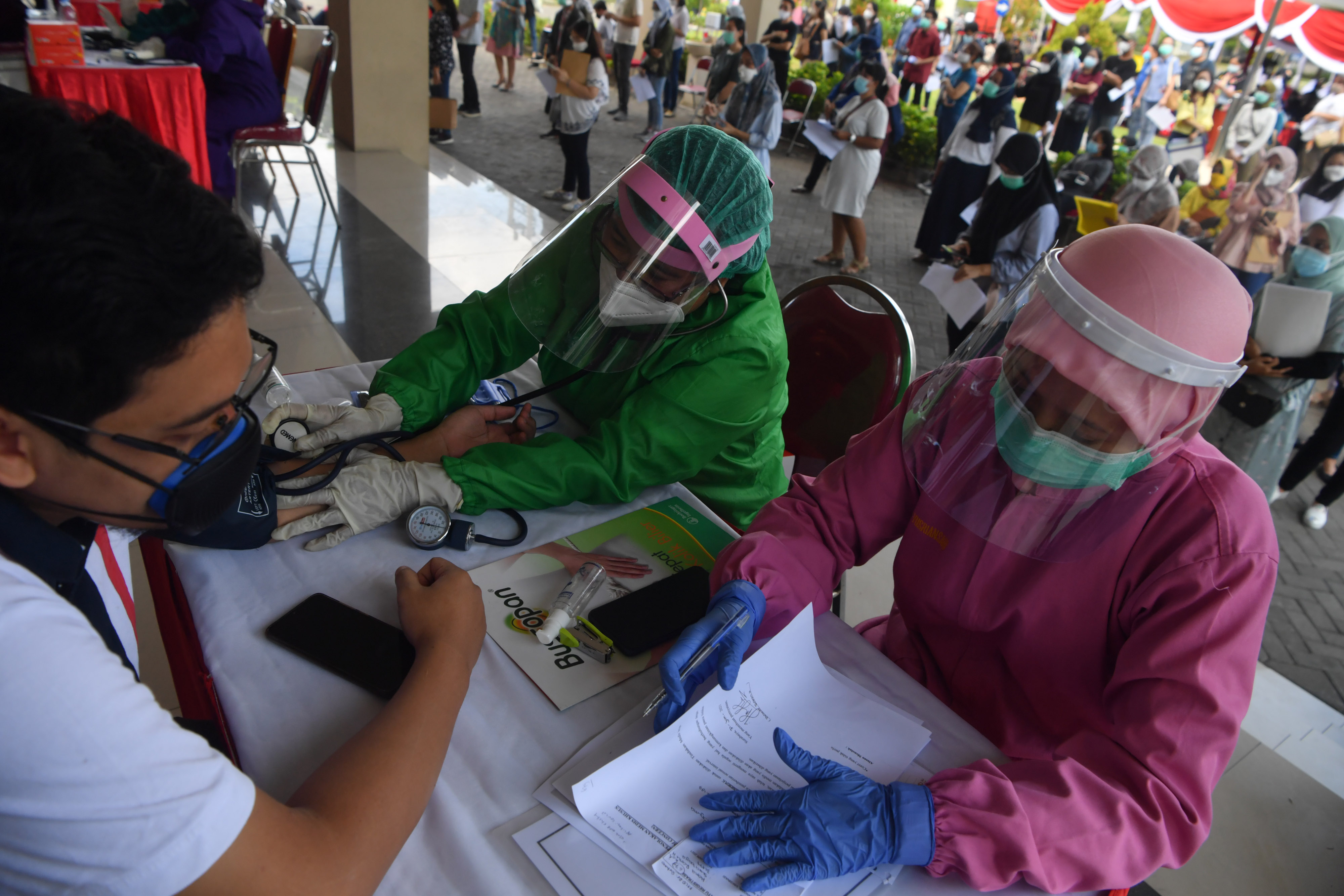 Petugas memeriksa kesehatan penerima vaksin covid-19 saat pelaksanaan vaksinasi massal di Surabaya, Jawa Timur, Minggu (31/1).