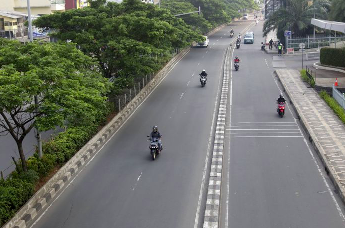Pengendara motor melintas di Jalan Margonda, Depok, Jawa Barat, Kamis (9/4).  