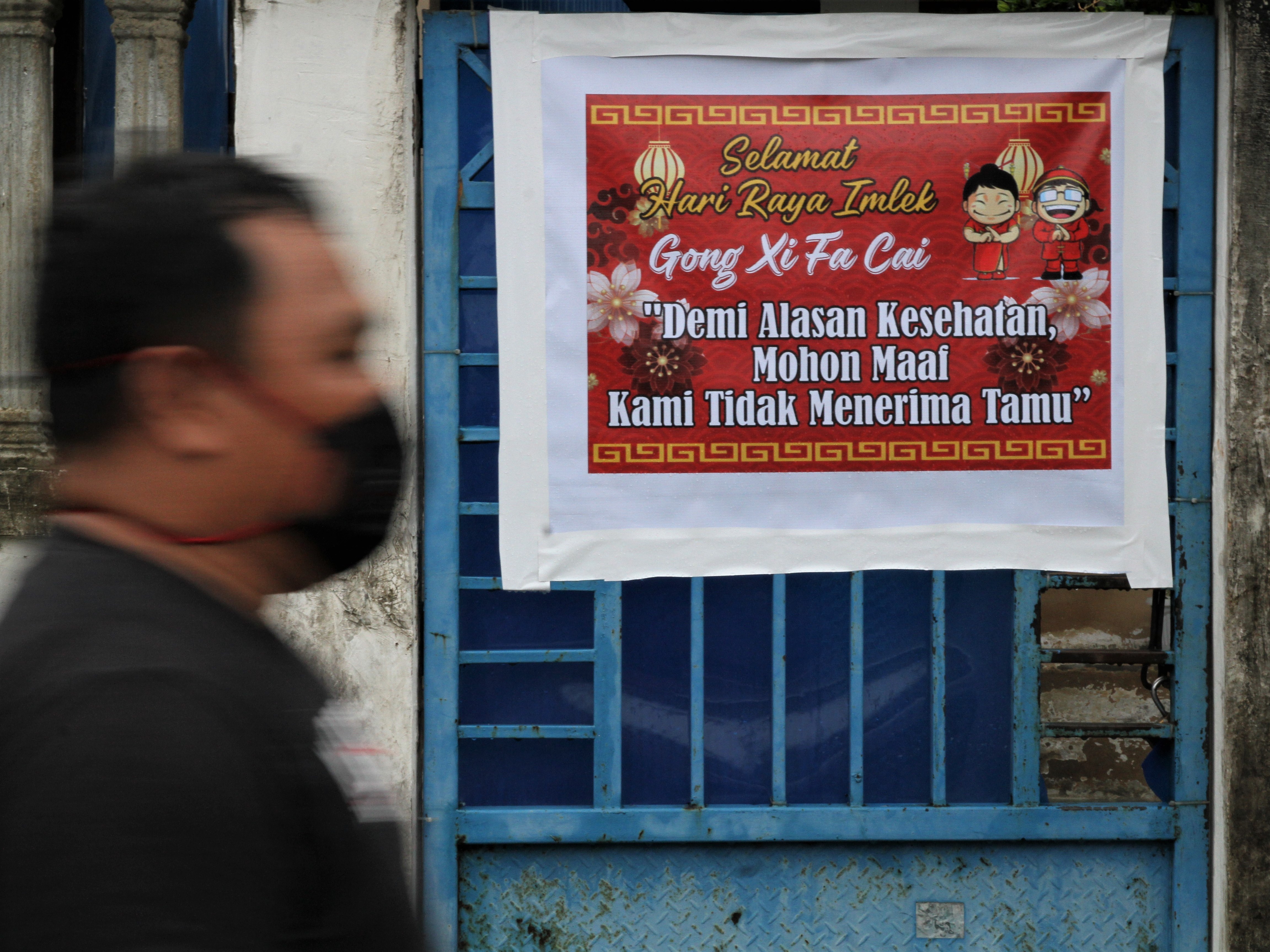 Poster bertuliskan ucapan Selamat Tahun Baru Imlek 2572 terpasang di pintu pagar rumah warga di Kendari, Sultra, Jumat (12/2).