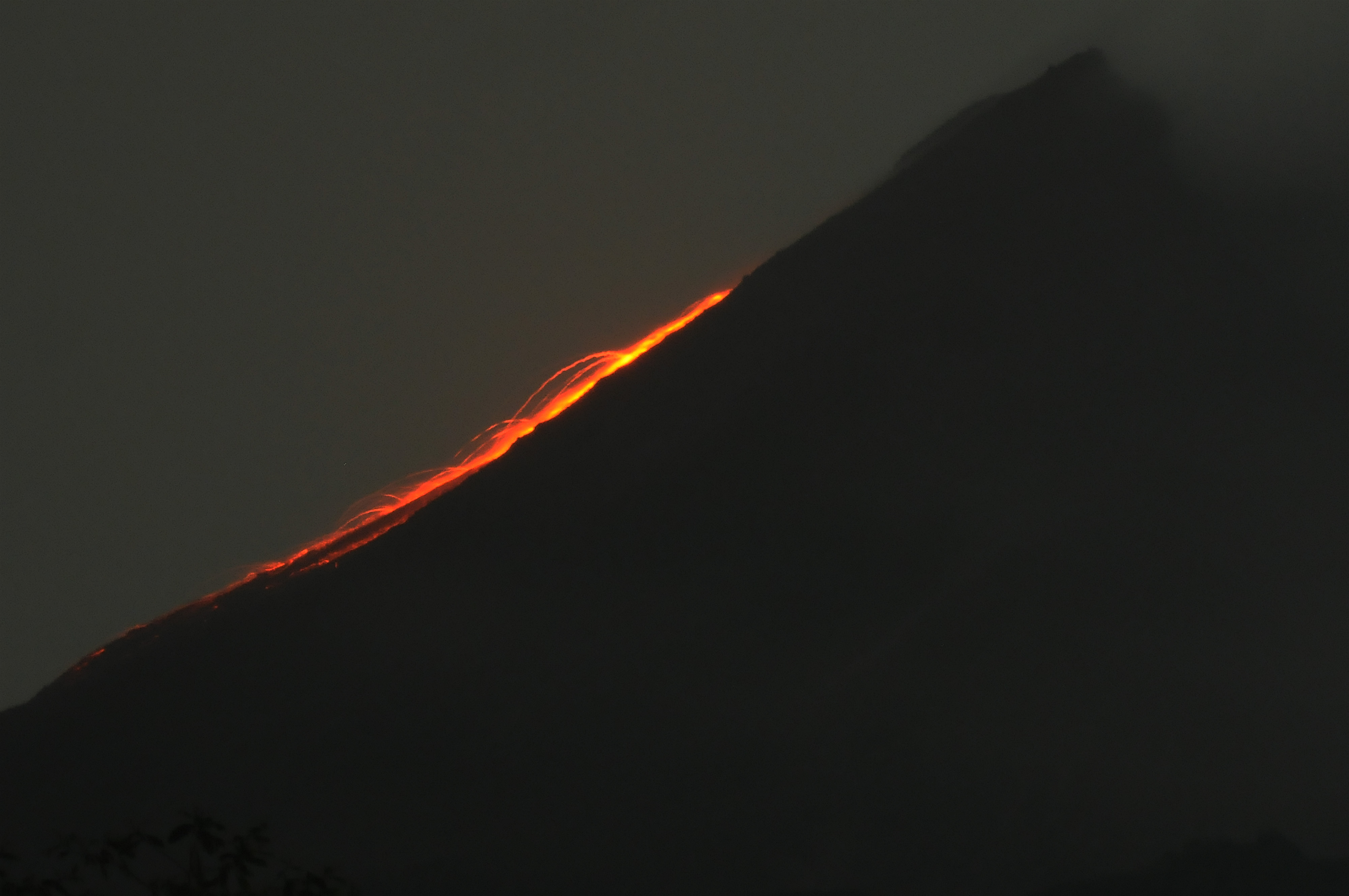 Guguran lava pijar terlihat menuruni lereng Gunung Merapi dari wailayah Balerante, Kemalang, Klaten, Jawa Tengah, Rabu (24/2/2021) malam