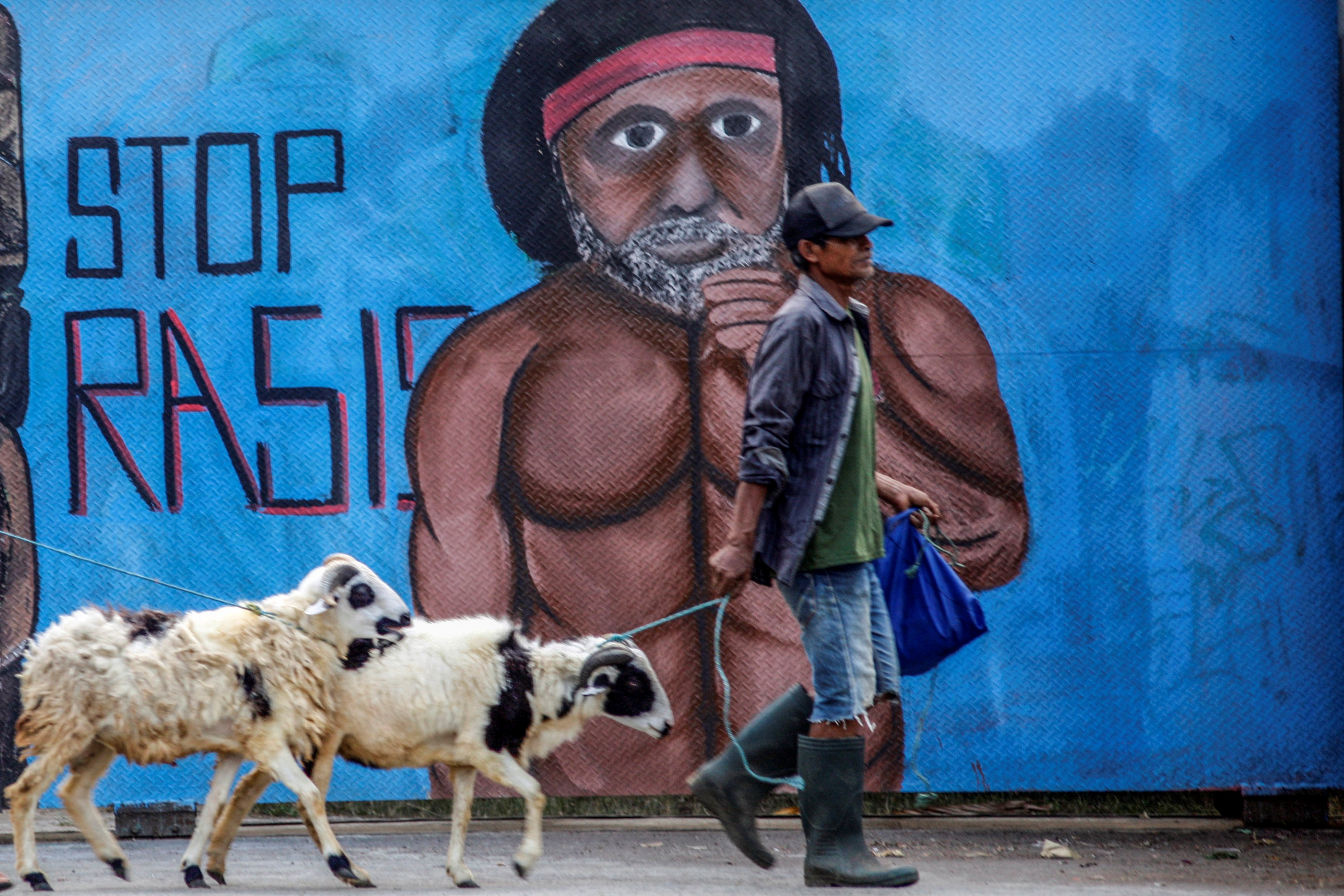 Warga melintas di depan mural bertema Antirasisme di Jalan Raya Bogor, Cilodong, Depok, Jawa Barat, beberapa waktu lalu..