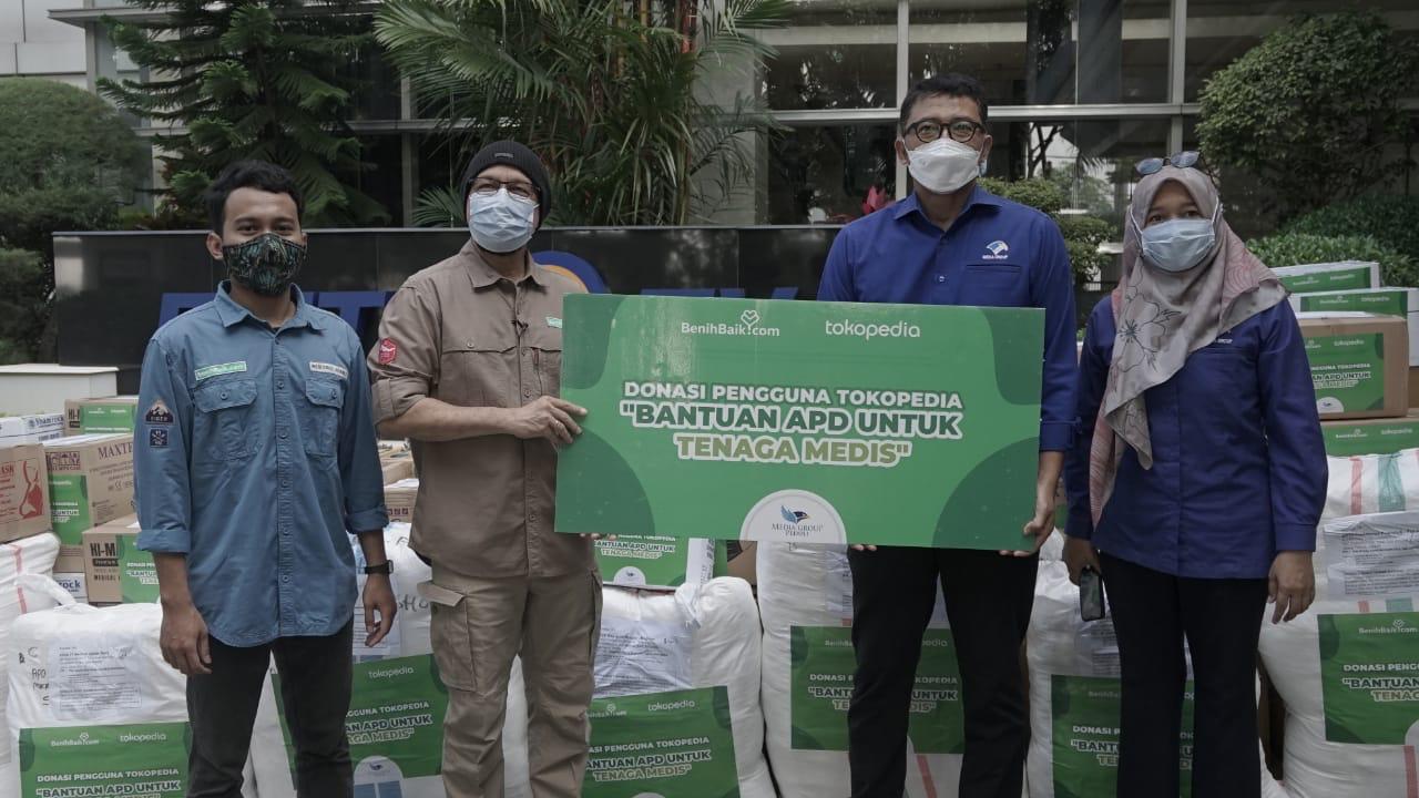 CEO BenihBaik.com Andi F Noya menyerahkan donasi dari pengguna Tokopedia kepada Dompet Kemanusiaan Media Group (DKMG).