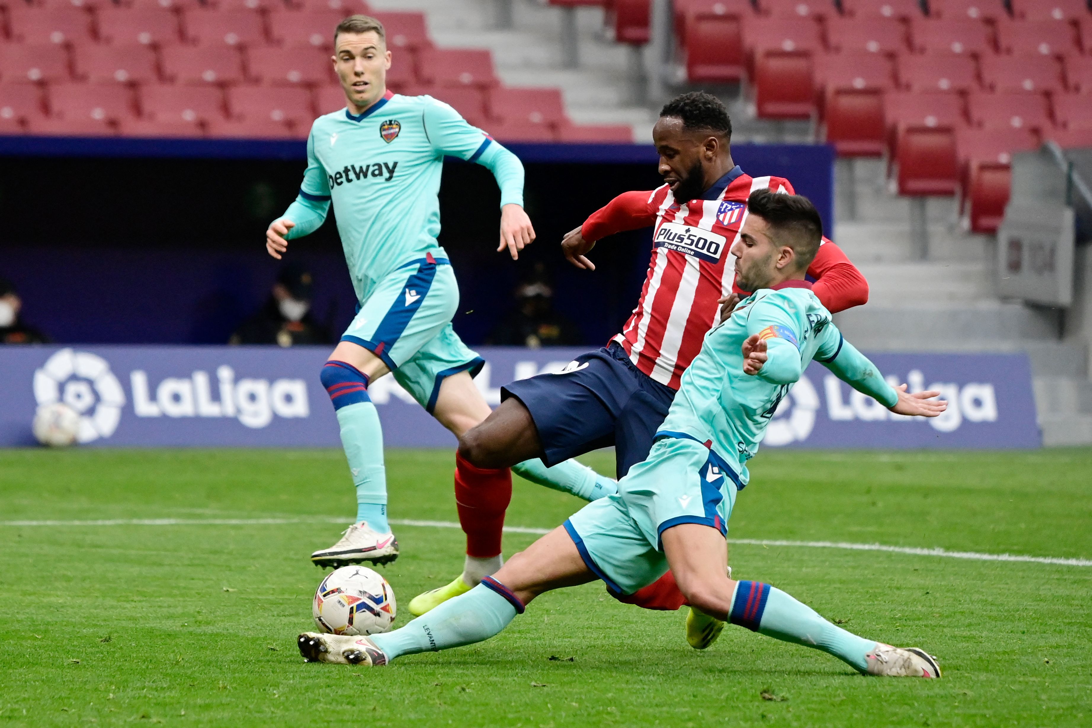 Pemain Atletico Madrid Moussa Dembele (tengah) dikepung dua pemain Levante' dalam pertandingan La Liga di Madrid, Spanyo, Minggu (21/2/2021)
