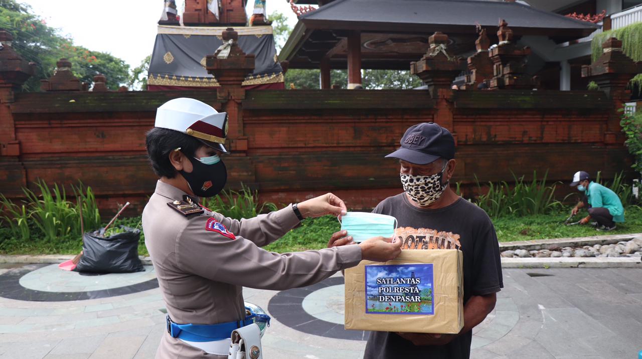 Seorang polisi wanita (kiri) tengah memberikan paket sembako kepada supir angkot.