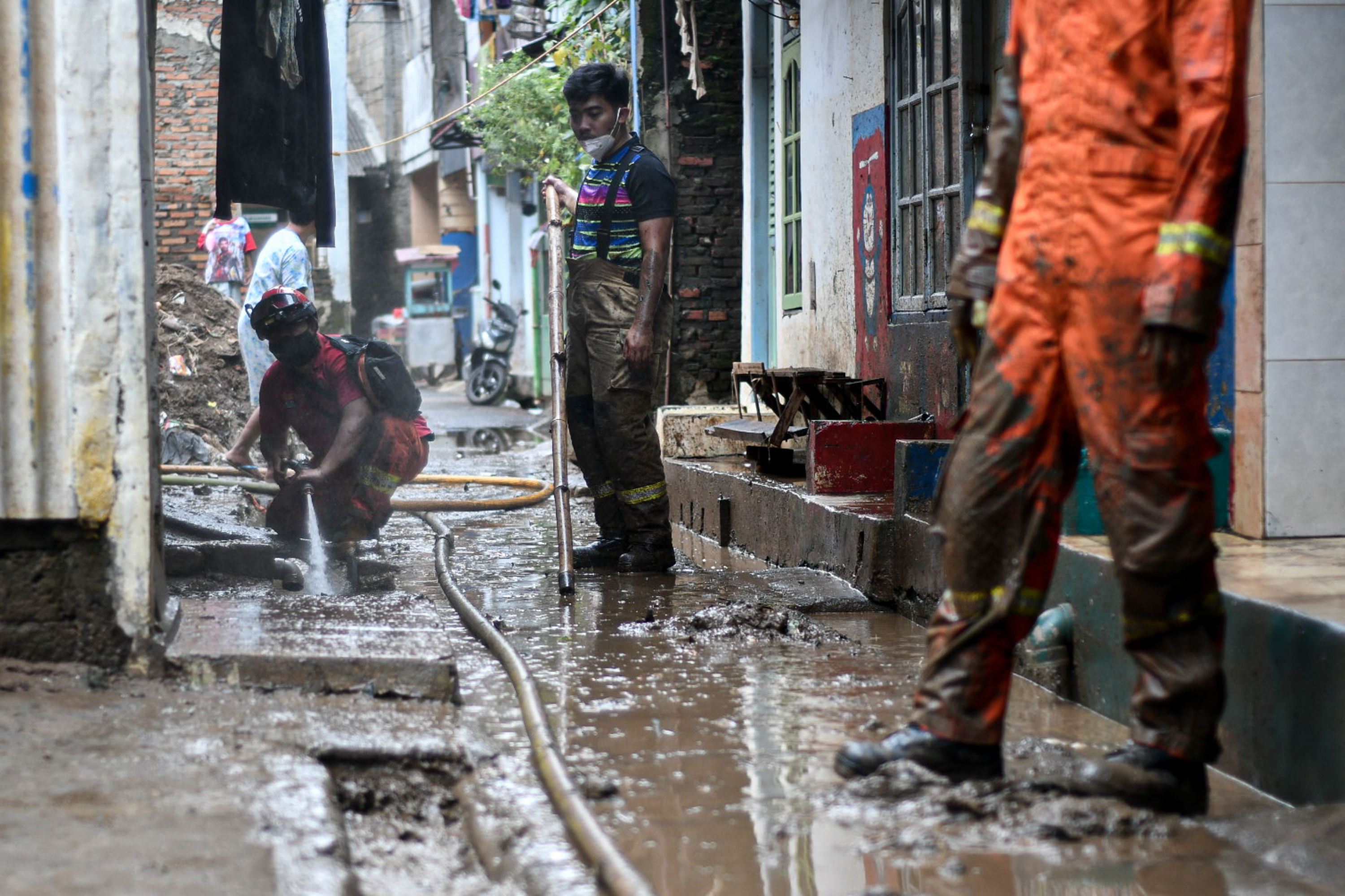 Warga membersihkan sisa lumpur bekas banjir