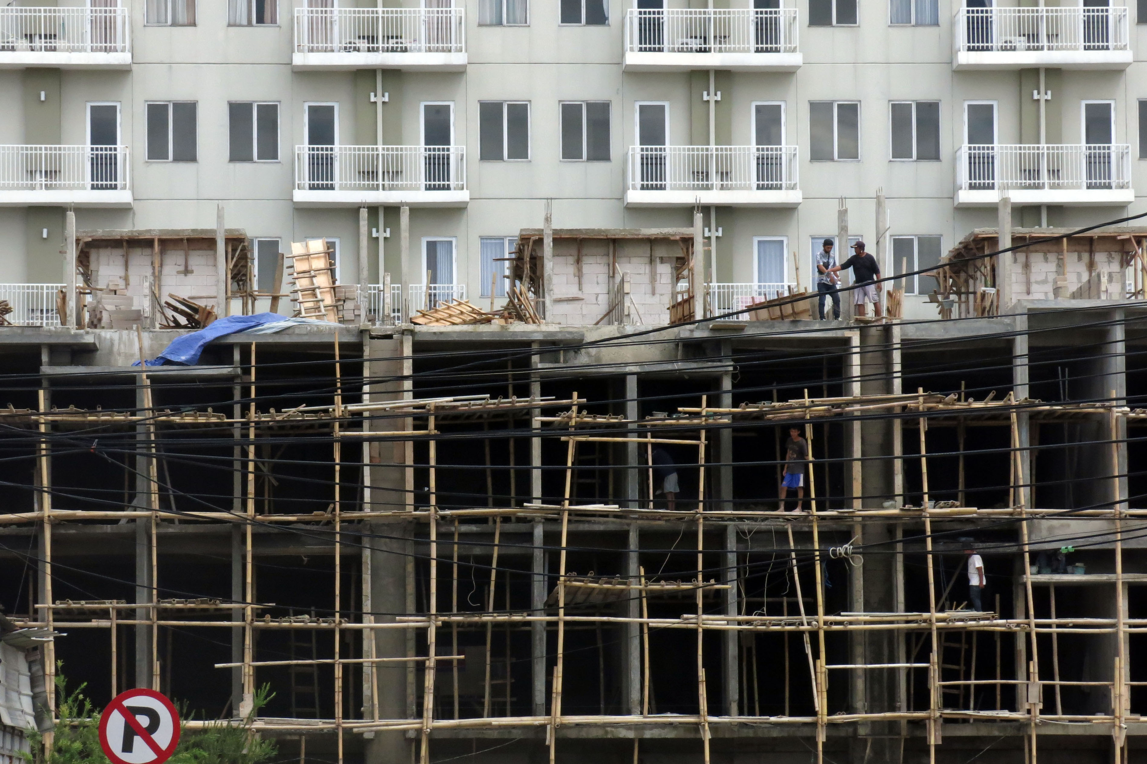 Pekerja menyelesaikan pembangunan apartemen di Kota Bogor, Jawa Barat, Selasa (26/1/2020)