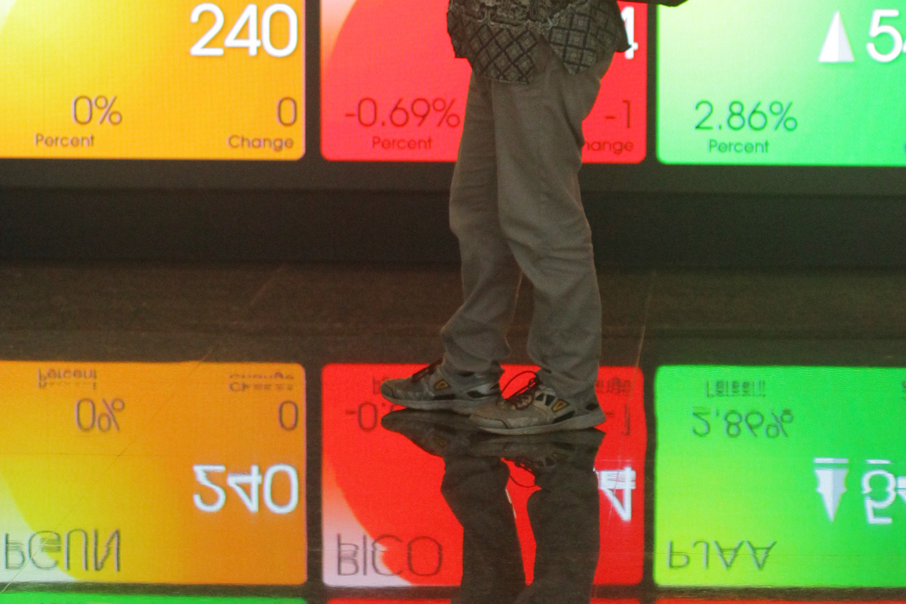 Refleksi karyawan saat melintasi layar Indeks Harga Saham Gabungan (IHSG) di Bursa Efek Indonesia, Jakarta, beberapa waktu lalu.