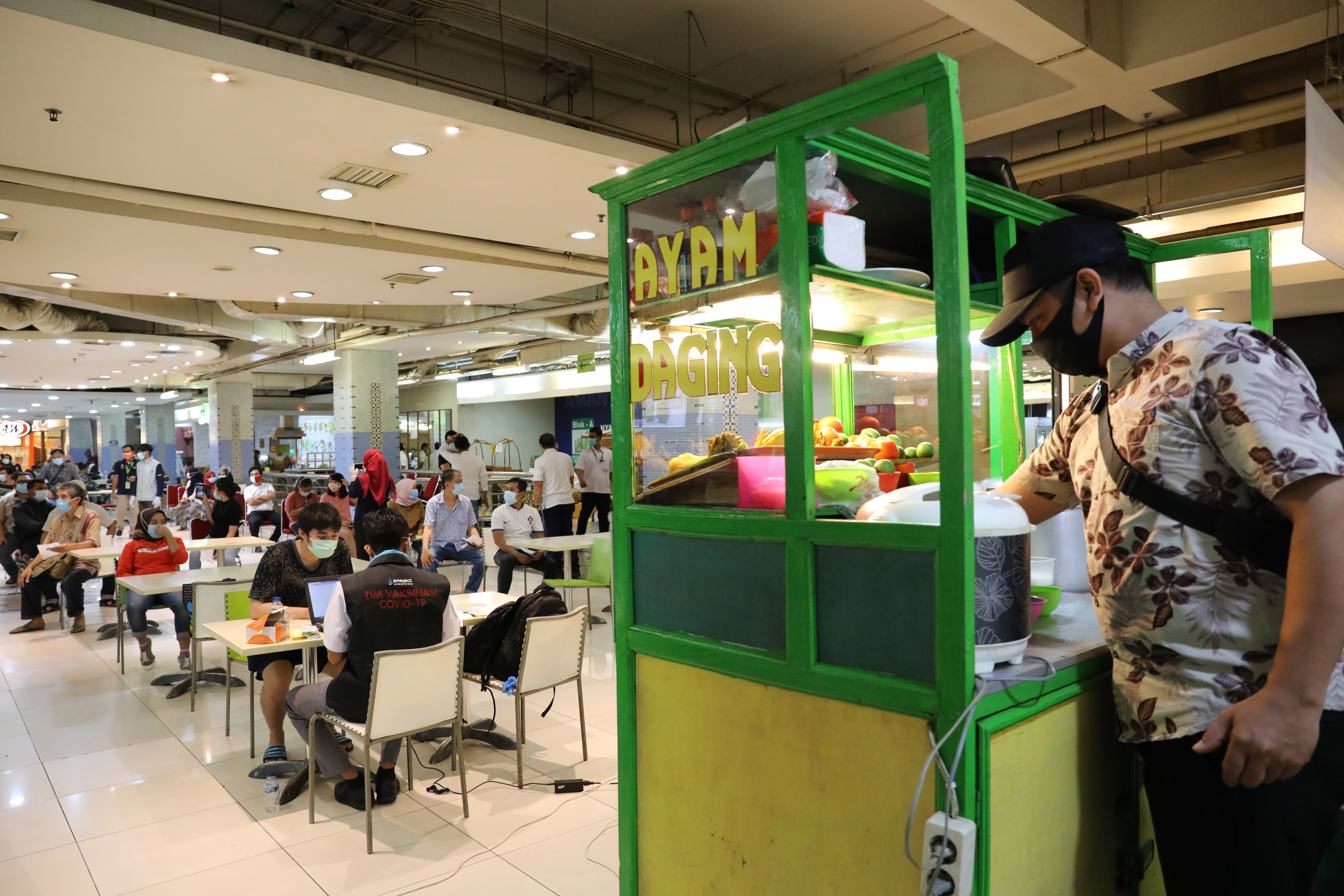 Pedagang dan pemilik toko antre menunjukkan rekam medis saat akan mengikuti vaksinasi Covid-19 di Pasar Tanah Abang, Jakarta, Rabu (17/2)