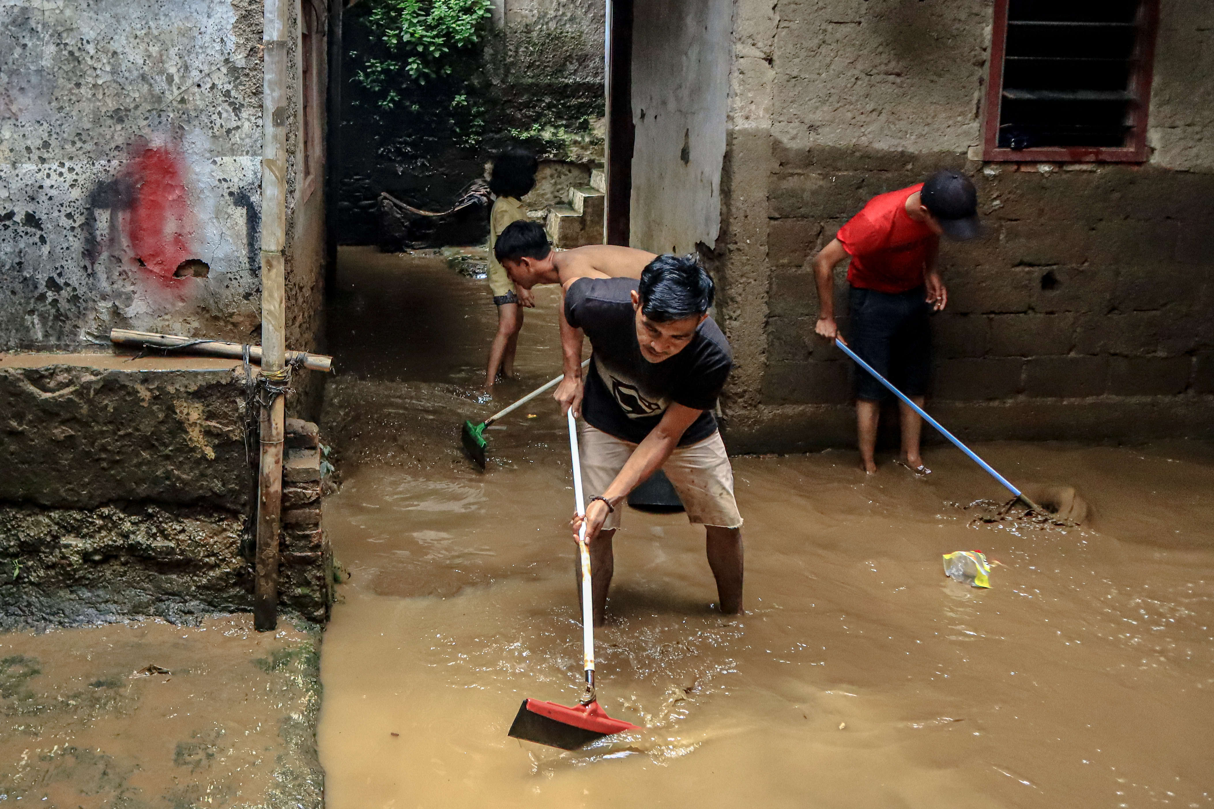 Warga membersihkan rumah dari sisa lumpur akibat banjir di Kawasan Manggarai Utara II, Jakarta, Selasa (9/2/2021)