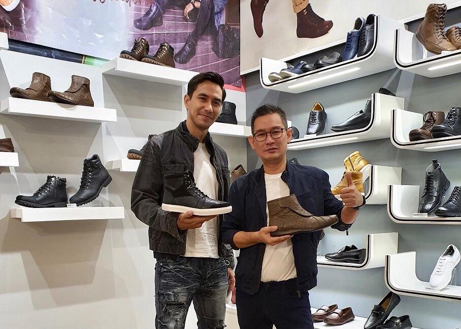 Selebritas Indonesia Darius Sinathrya bersama GM Gino Mariani Denny Budianto sedang memamerkan koleksi sepatu kolaborasi mereka.