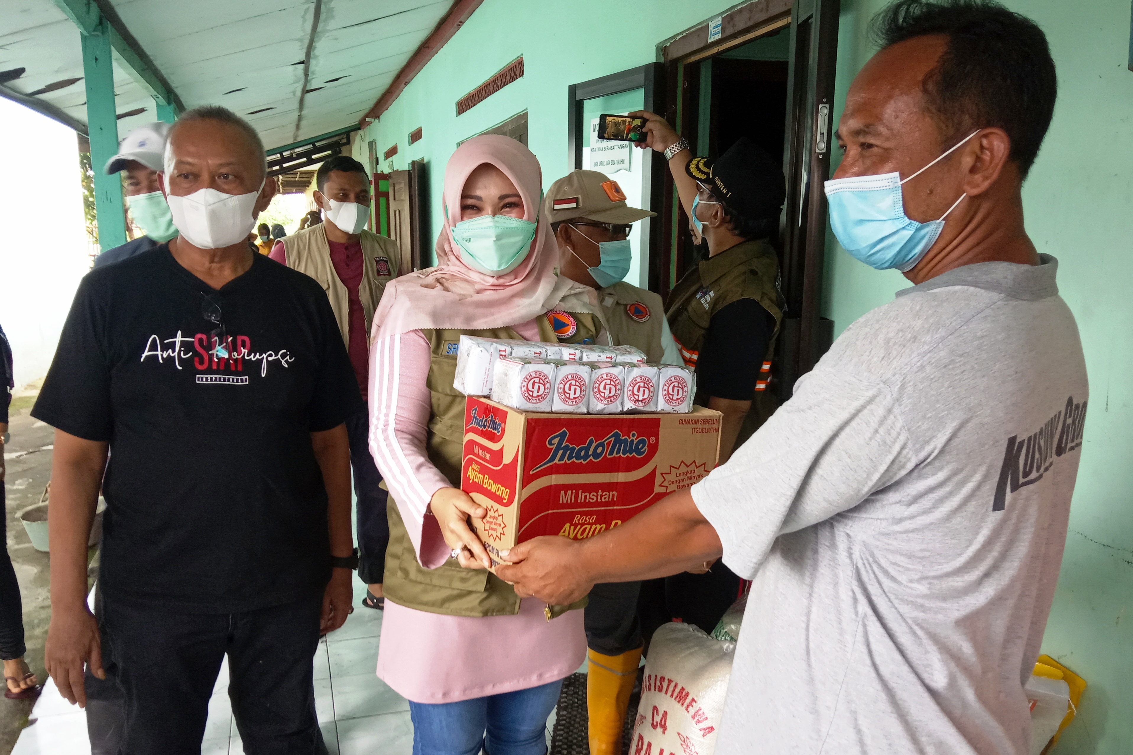 Bupati Sri Mulyani didampingi Sekda Jaka Sawaldi menyerahkan bantuan sembako di Posko Banjir Desa Pesu.