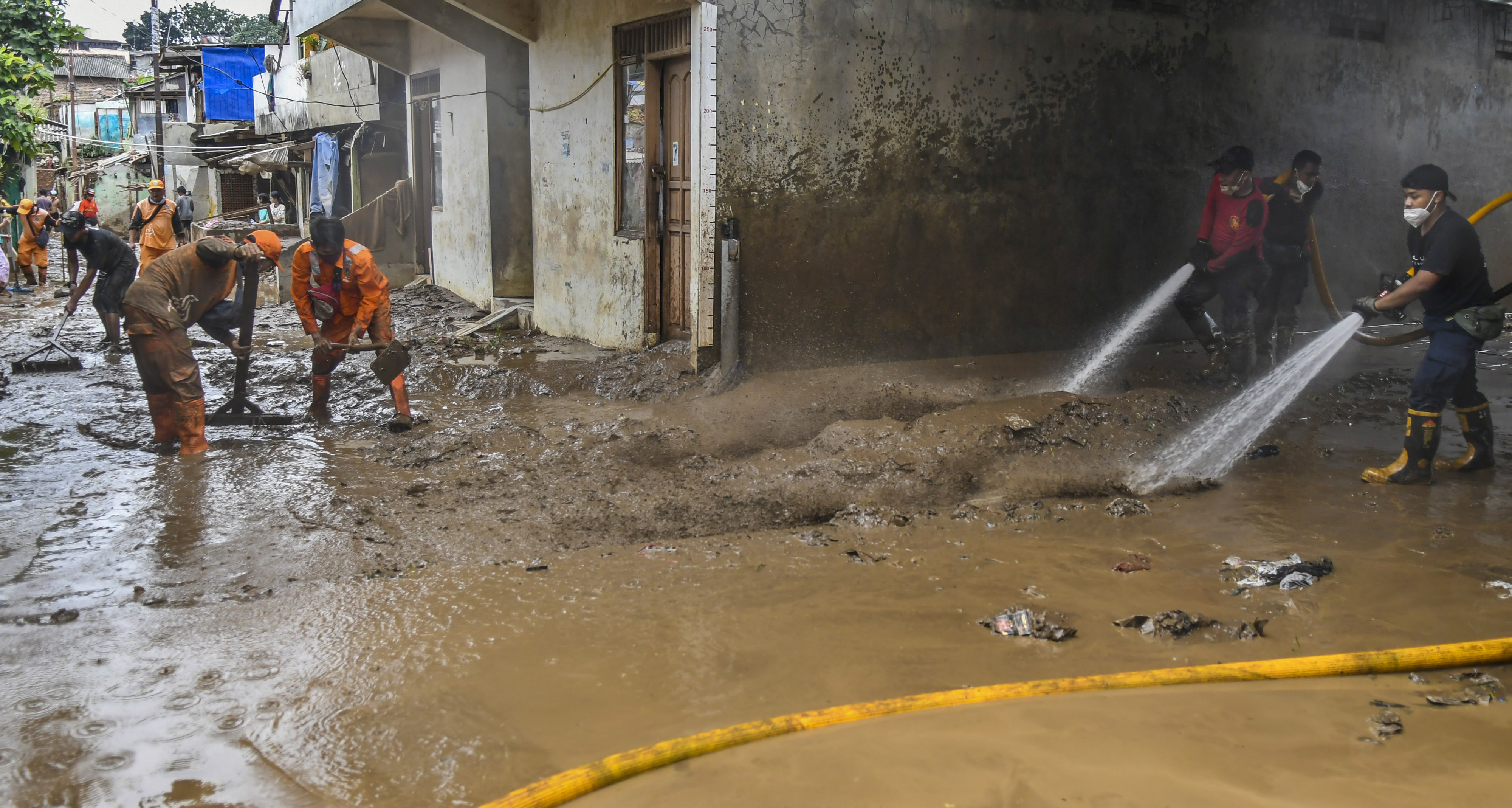 Pemadam kebakaran dan warga membersihkan sisa banjir di Pejaten Timur, Jakarta