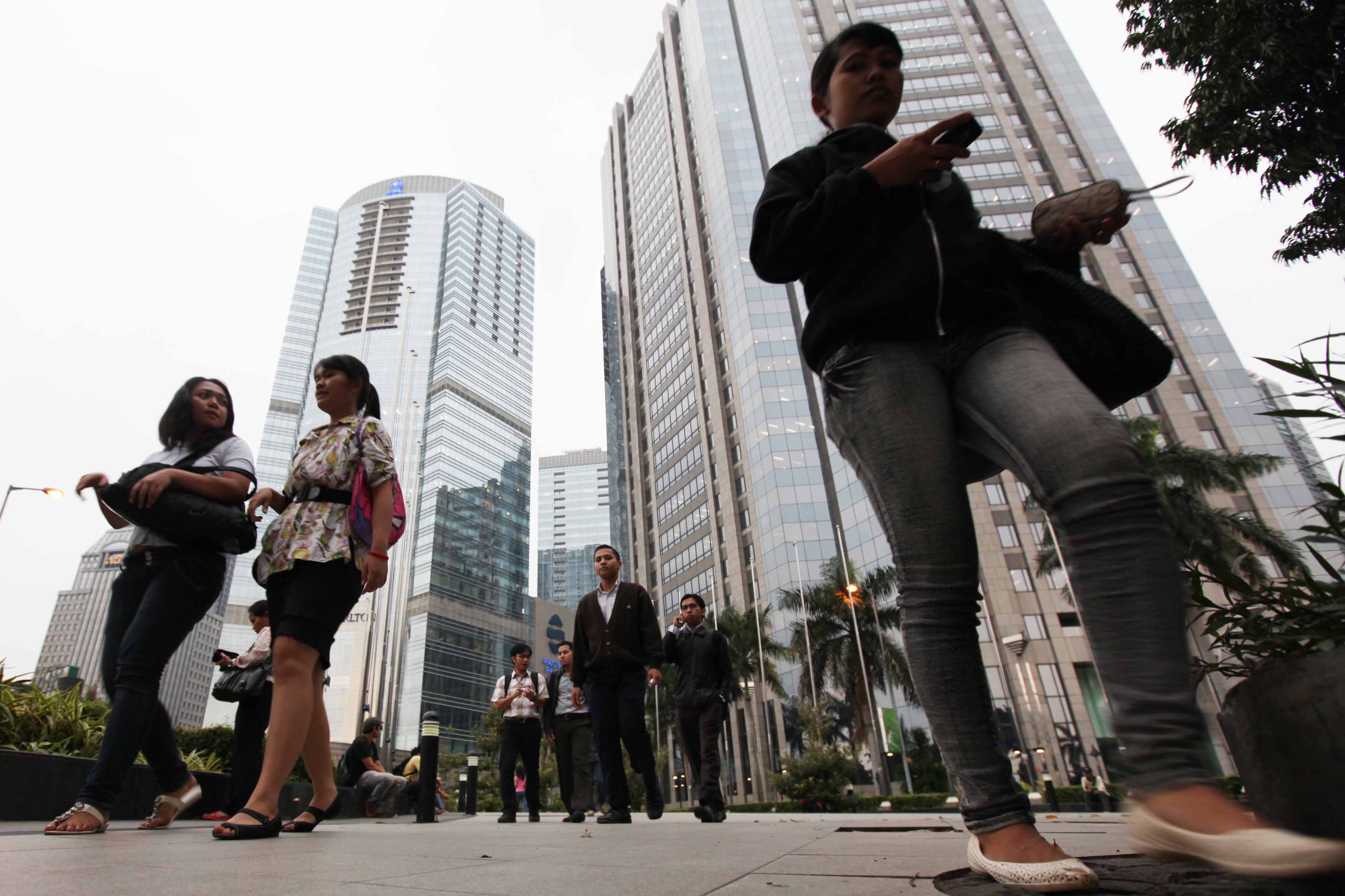 Pekerja kantoran di Jakarta melintas di kawasan SCBD. ABP mengumumkan aliansi strategis di kantor afiliasi ABP Jakarta. 