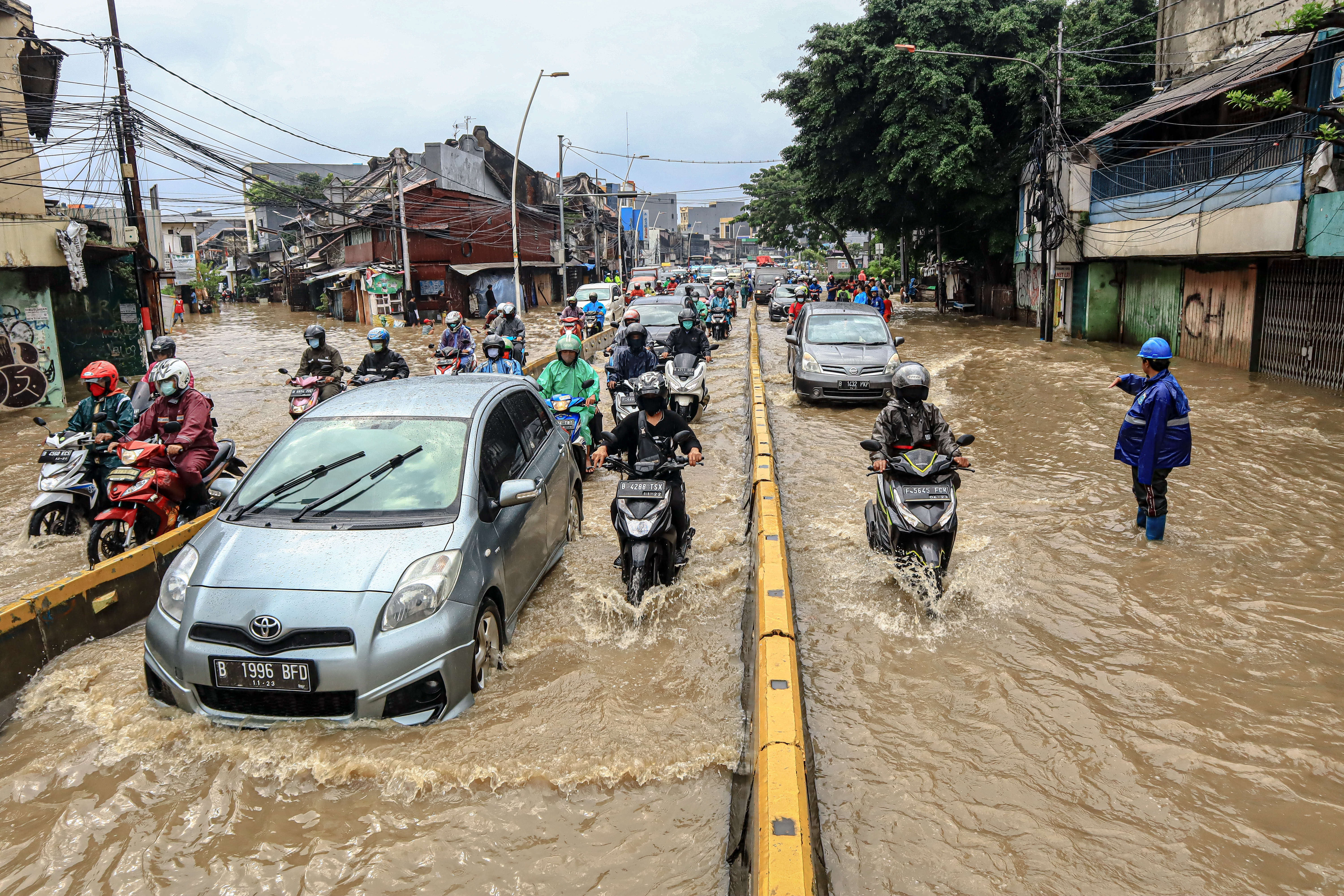Kendaraan melintas genangan air di Kawasan Jatinegara, Kampung Melayu, Jakarta