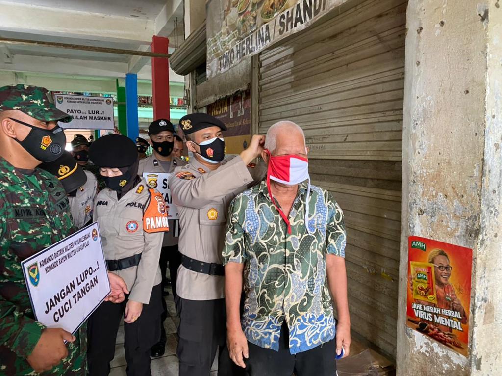 Polda Sumsel membagikan masker kepada para pengunjung dan pedagang di Pasar Plaju Palembang, pada Sabtu (23/2).