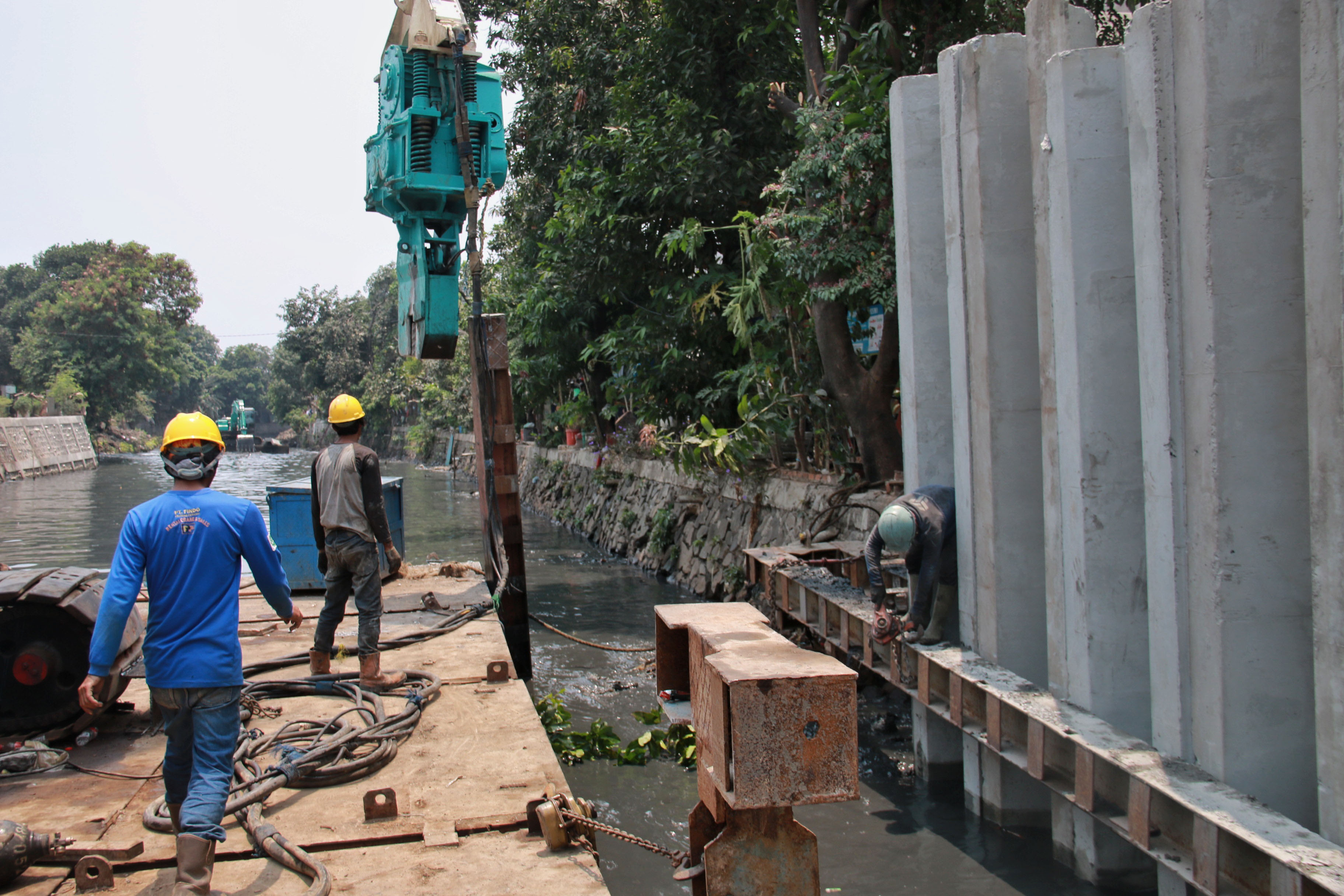 Pekerja menyelesaikan pembangunan tanggul sungai di Kali Krukut, Jakarta Utara, Selasa (8/10/2019).
