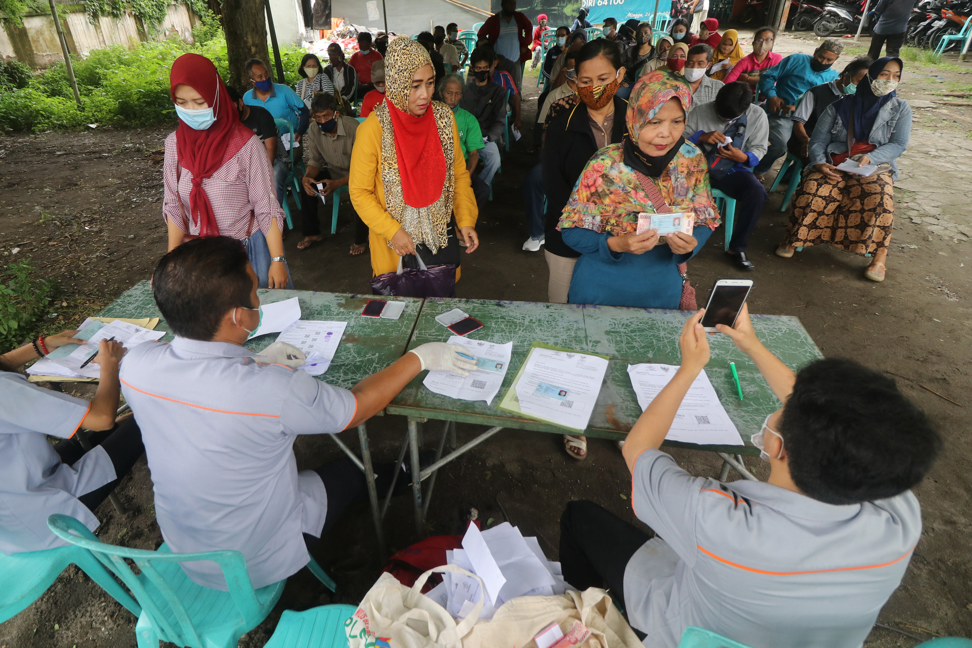 PENERIMA BST BERTAMBAH: Warga terdampak pandemi covid-19 mencairkan BST tahap kedua di halaman kantor Pos Kota Kediri, Jawa Timur