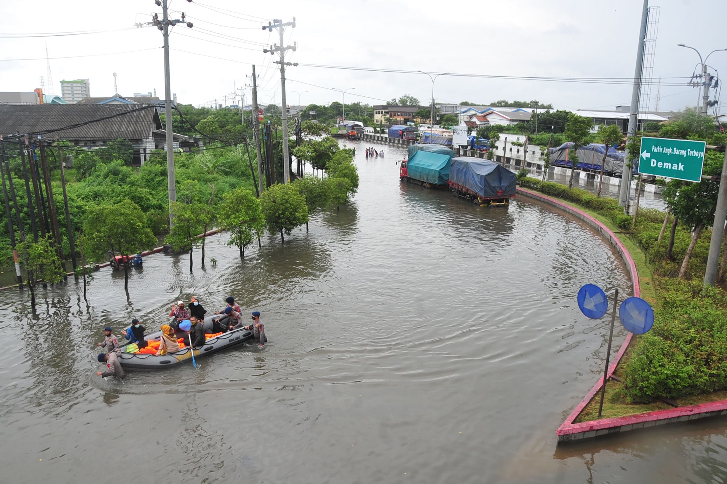 Aparat kepolisian memberi bantuan transportasi dengan perahu karet di tengah Kota Semarang, Jawa tengah, yang dilanda banjir. 