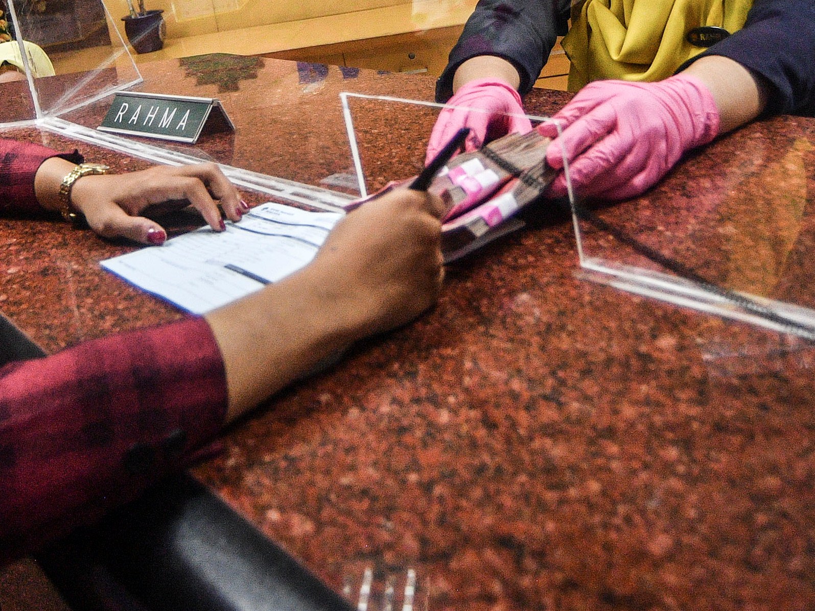 Karyawan bank melayani nasabah.