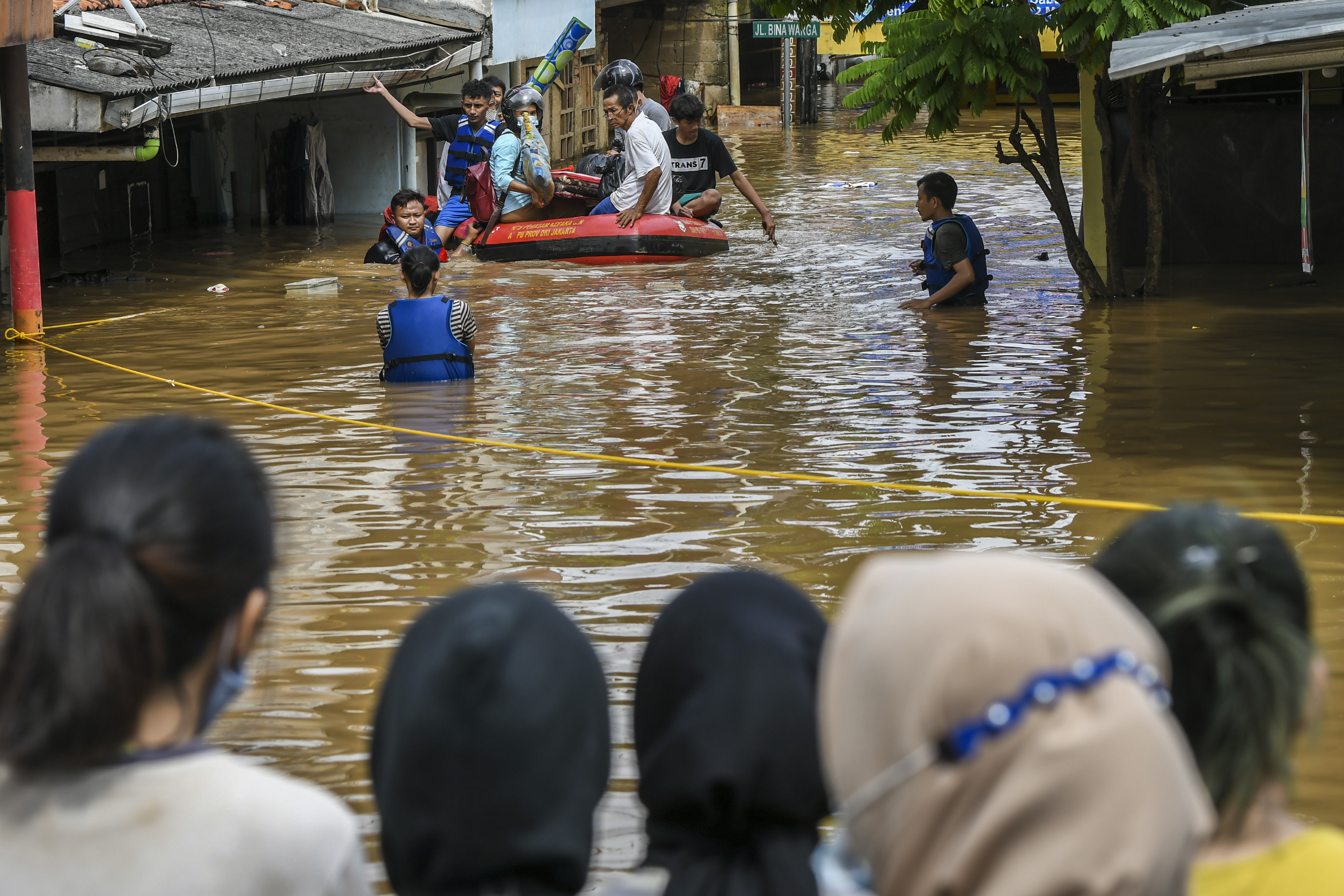 Petugas menggunakan perahu karet mengevakuasi warga yang rumahnya terendam banjir di Kawasan Rawajati, Kalibata, Jakarta, hari ini.