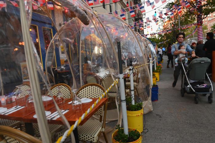 Warga makan di dalam tenda-tenda plastik di sebuah restoran di New York, Amerika Serikat, untuk memastikan protokol kesehatan dijalankan.