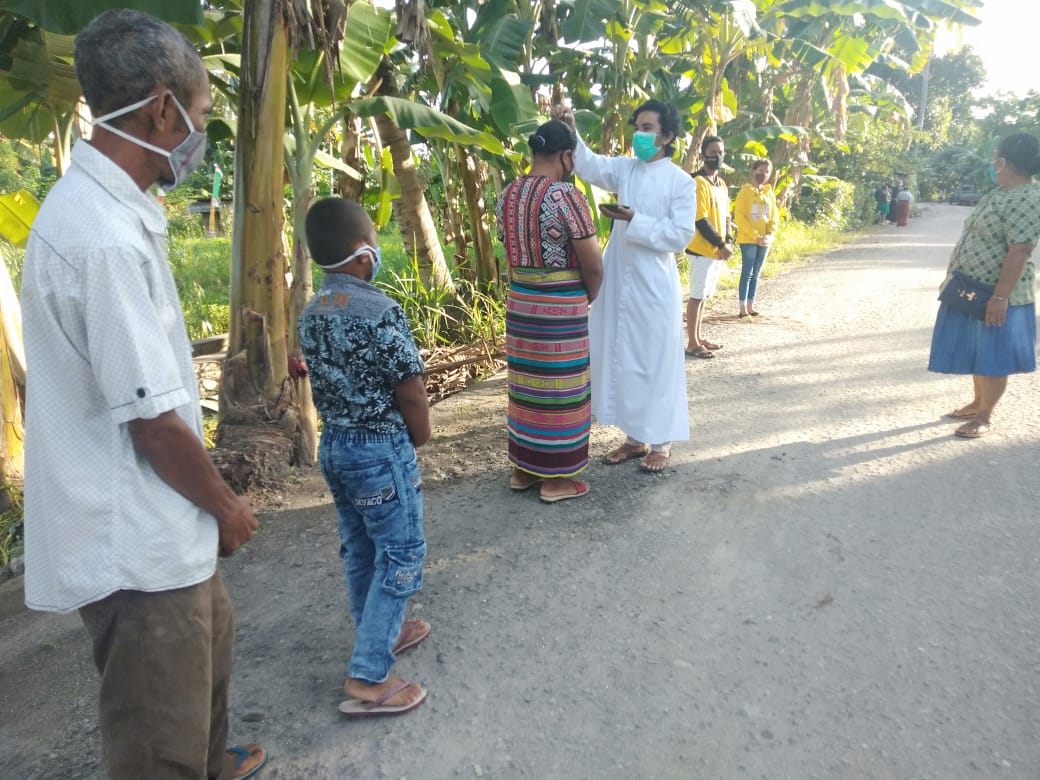 Frather dari Paroki Gereja St Arnoldus Jansen Waikomo, Lembata menandai kening umat Katolik dengan abu dalam perayaan Rabu, Rabu (17/2/2021)