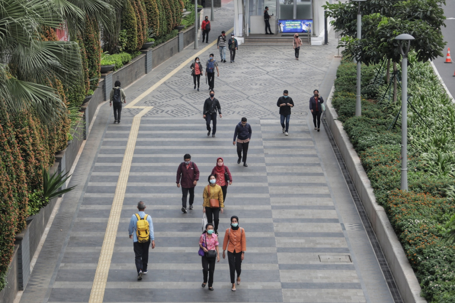 tenaga kerja melintas di trotoar Jalan jenderal Sudirman pada jam pulang kerja