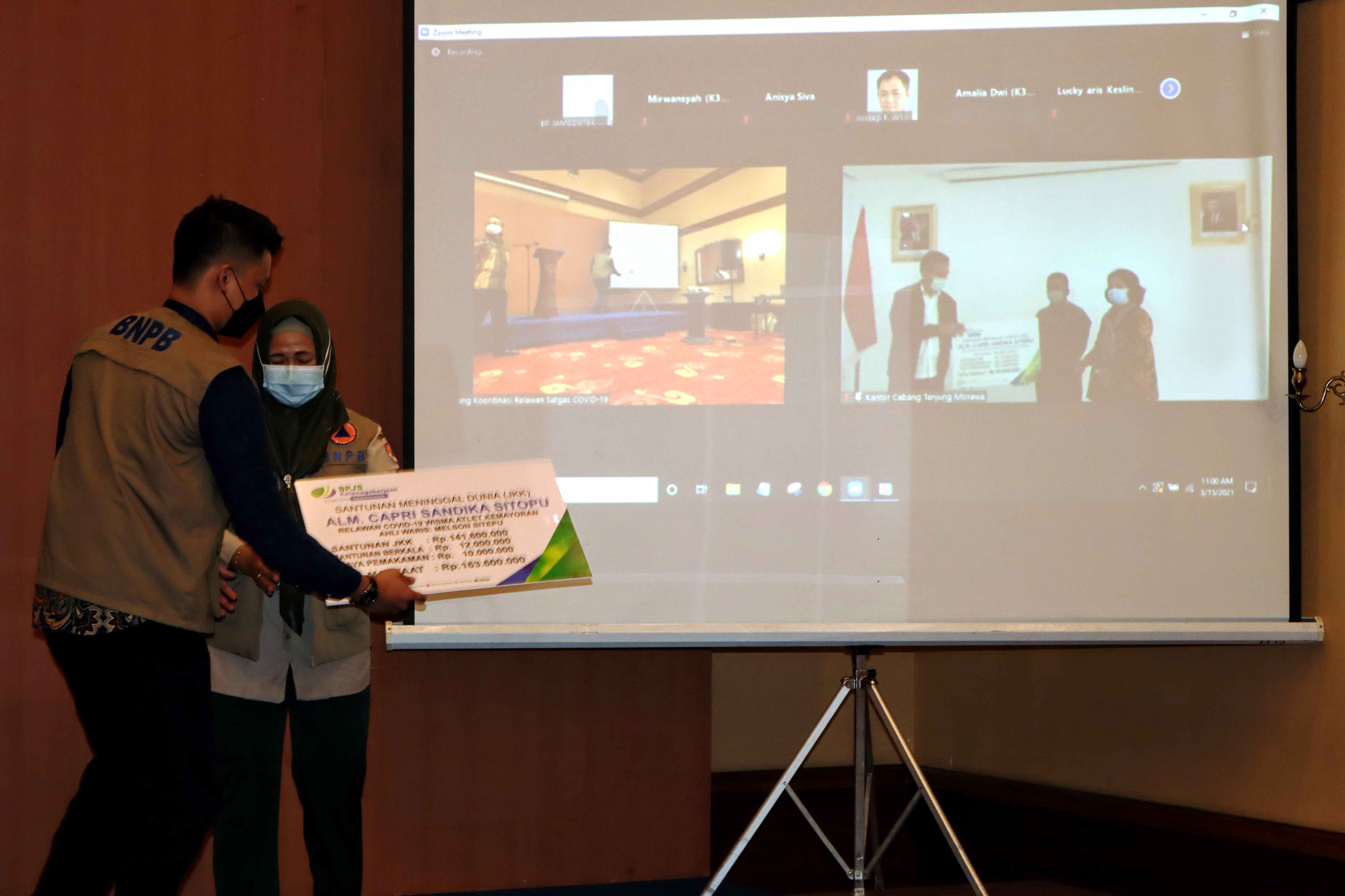 PENYERAHAN BANTUAN: Direktur Kesiapsiagaan BNPB Eny Supartini (kiri) menyaksikan penyerahan santunan kepada ahli waris relawan covid-19