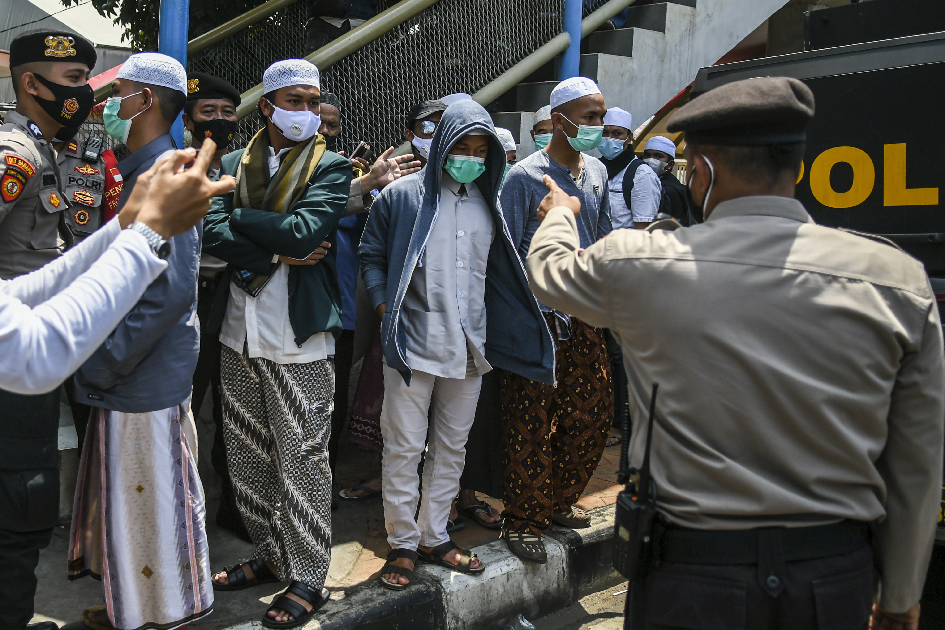 Petugas kepolisian membubarkan pendukung Rizieq Shihab saat berlangsungnya persidangan di Pengadilan Negeri Jakarta Timur, Jumat (26/3).
