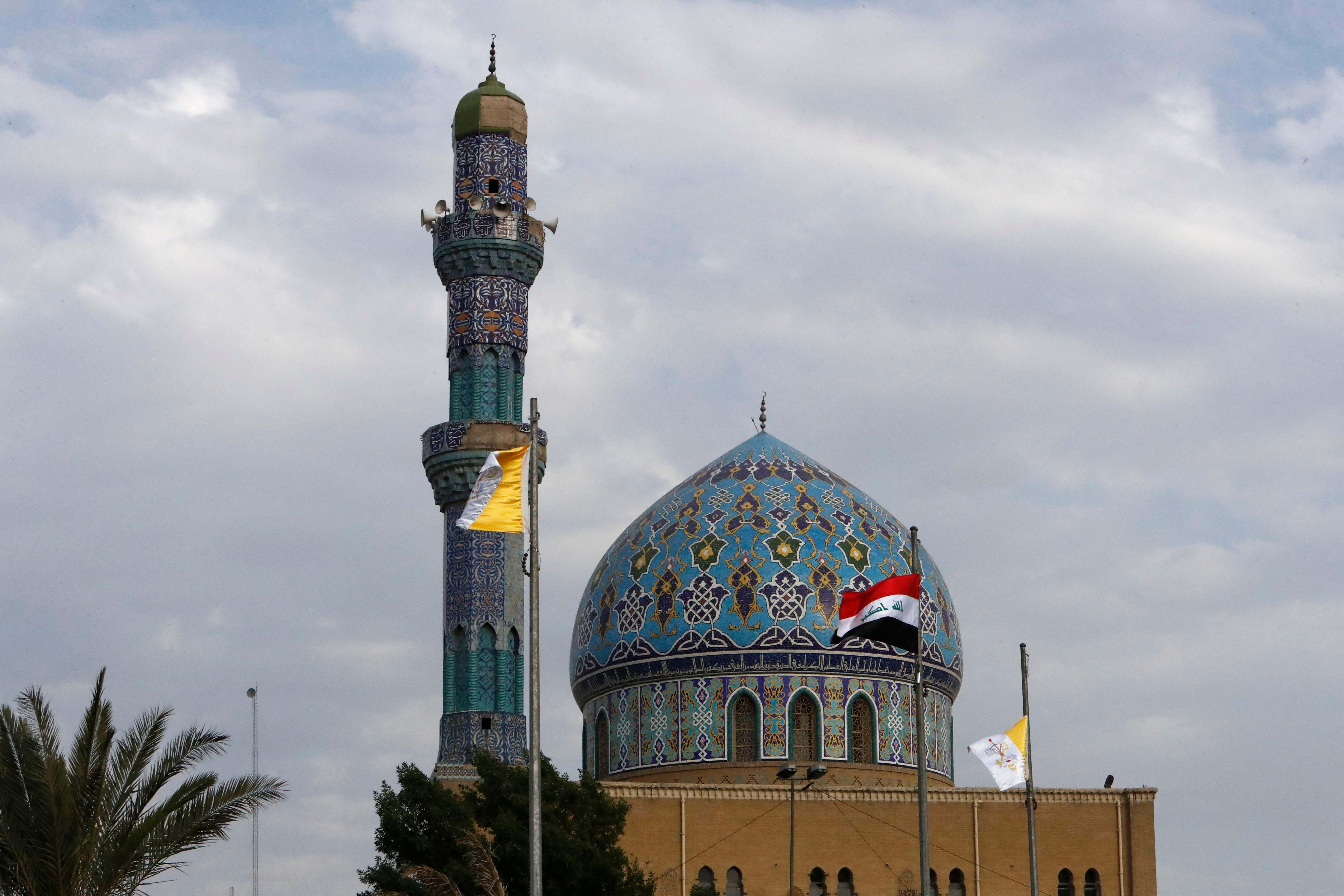 Bendera Irak dan Vatikan digambarkan di luar masjid al-Fidos di ibu kota Baghdad pada Kamis (4/3).